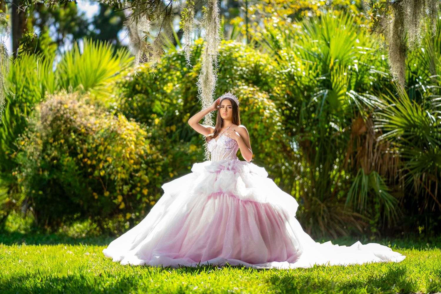 A romantic bridal portrait session in a lush garden setting with Spanish moss and palm trees creating a dreamy atmosphere.