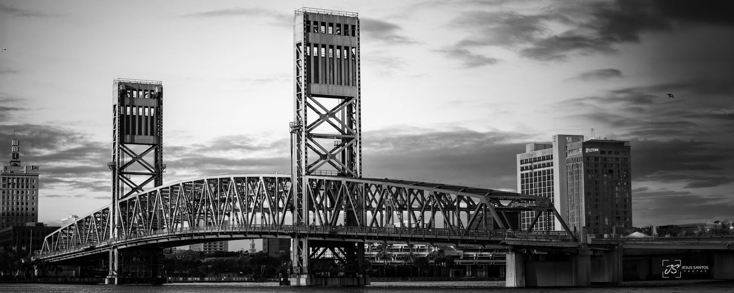 Five black and white dramatic panoramic images of railroad bridge crossings over water with cloudy skies.