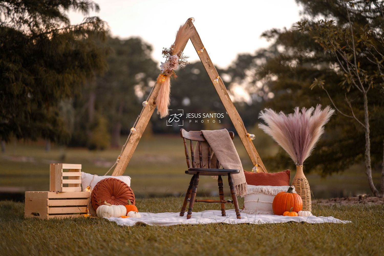 Cozy outdoor teepee style tent decorated with lights and cushions for a romantic picnic setting at sunset.