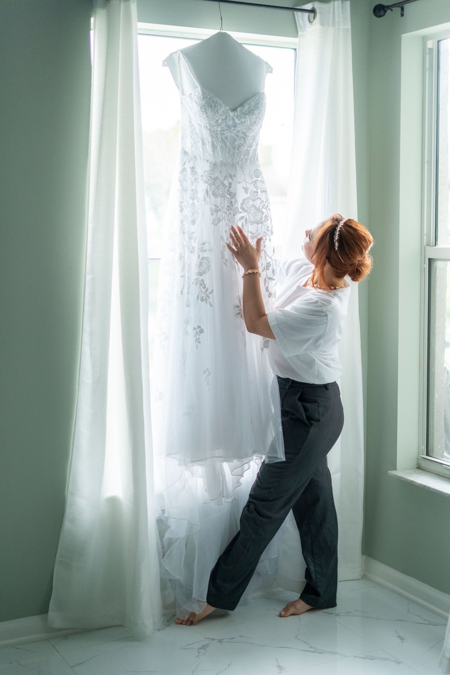 A sequence of photos showing someone adjusting a white wedding dress hanging near a window in a bright room.