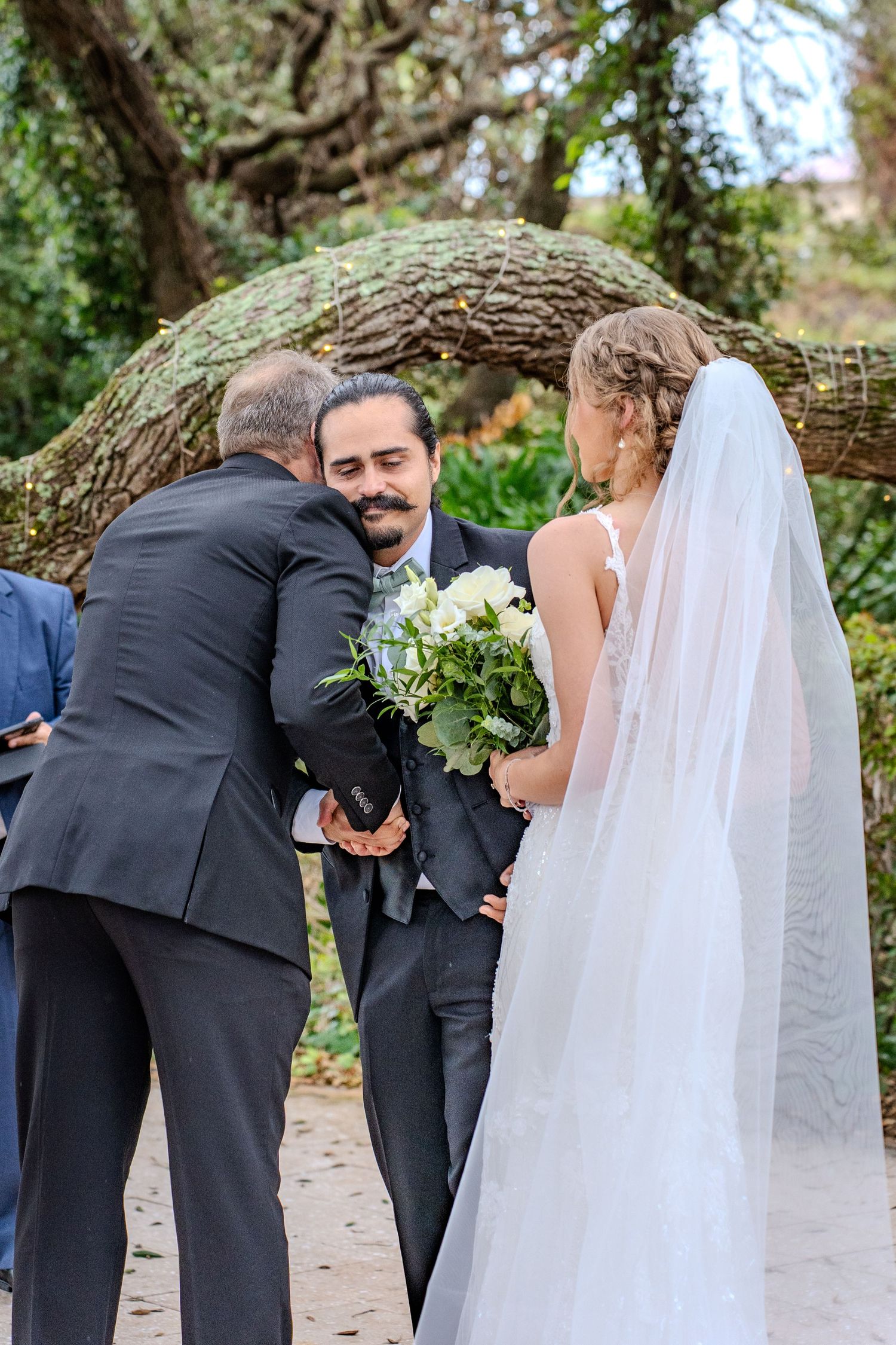 Wedding ceremony sequence under twisted oak trees showing tender moments between the couple.