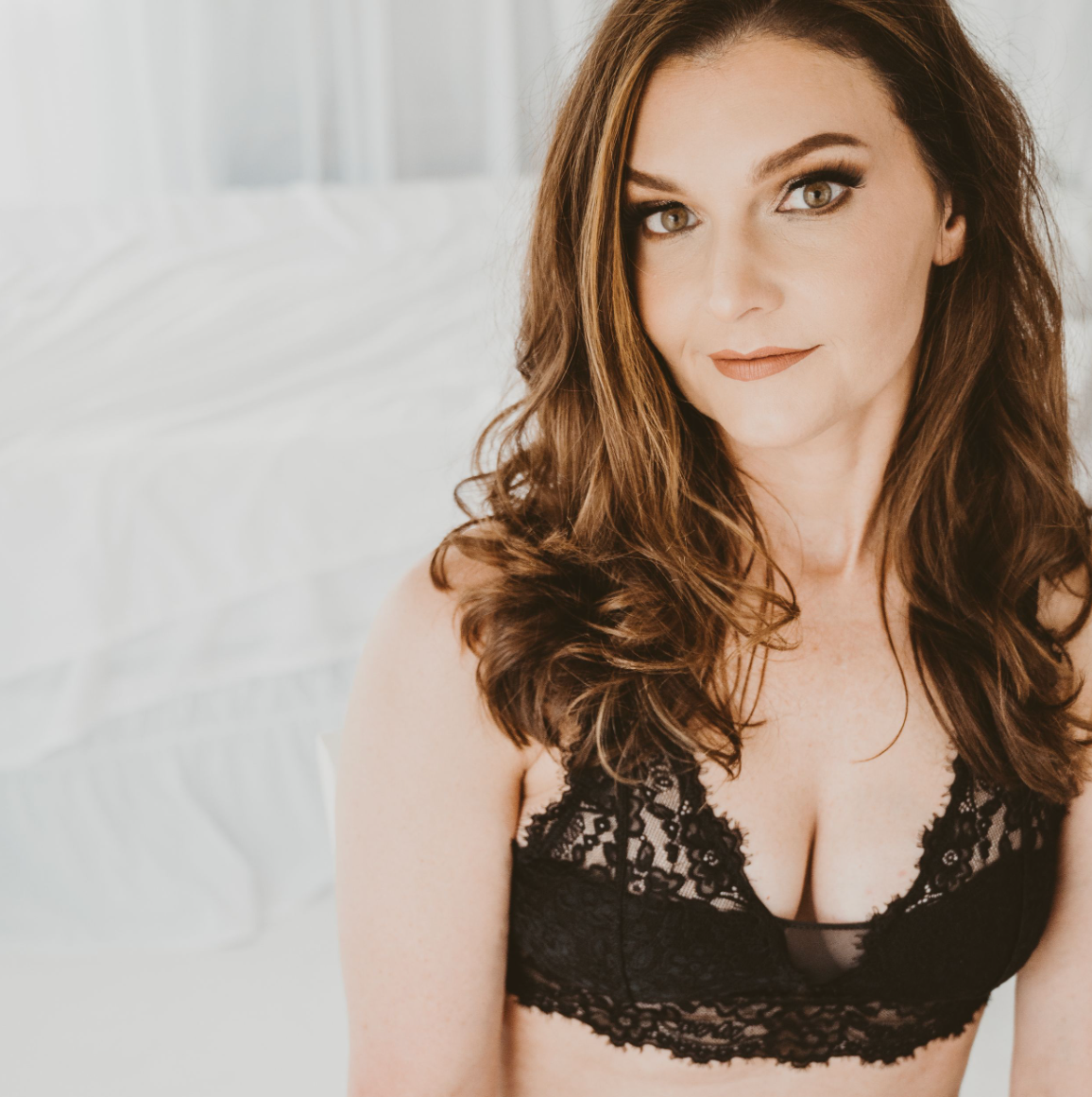 boudoir photo of woman in black top with empowered look.