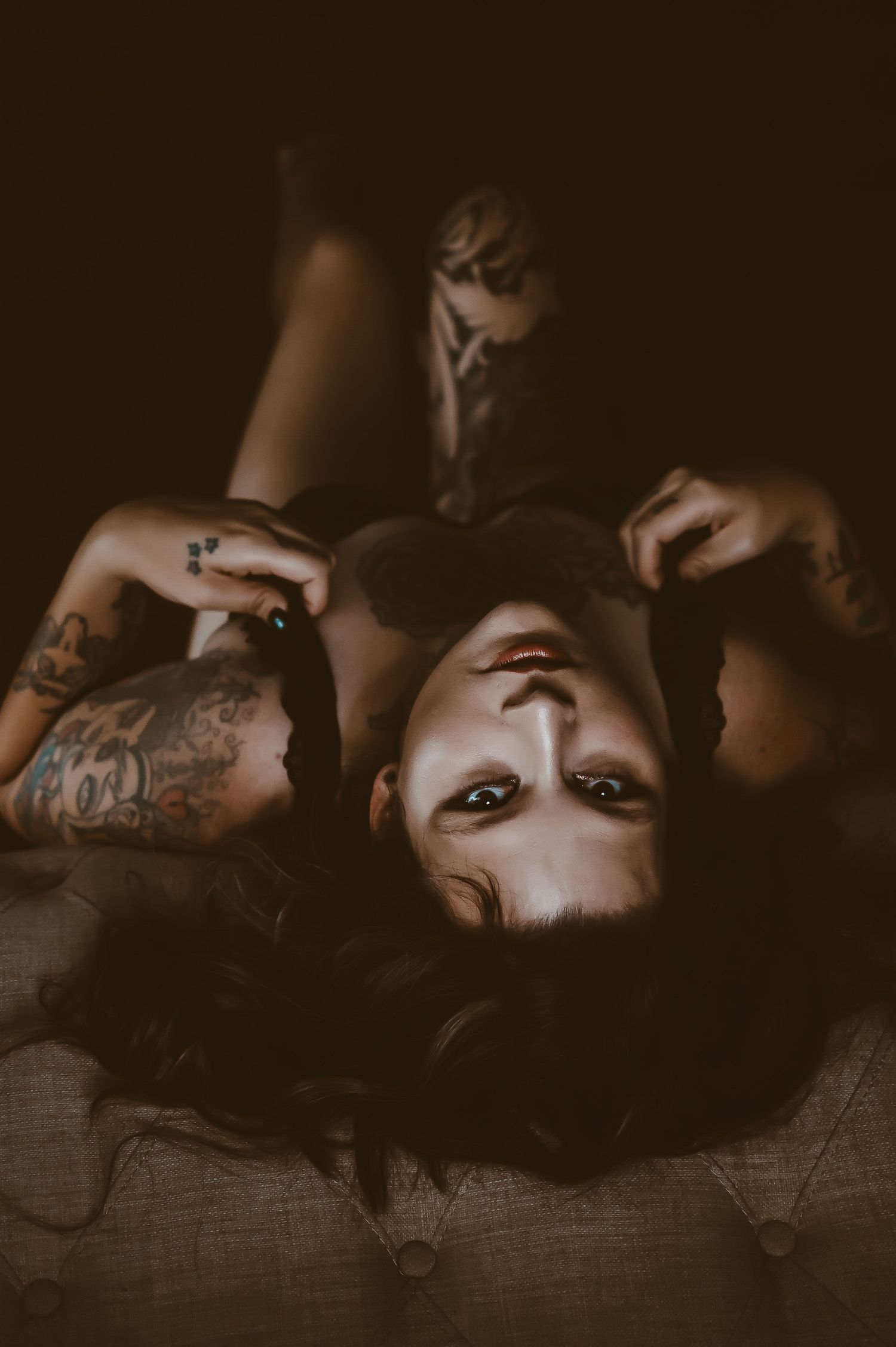 Moody boudoir portrait – confident woman in black lingerie, relaxed and empowered.