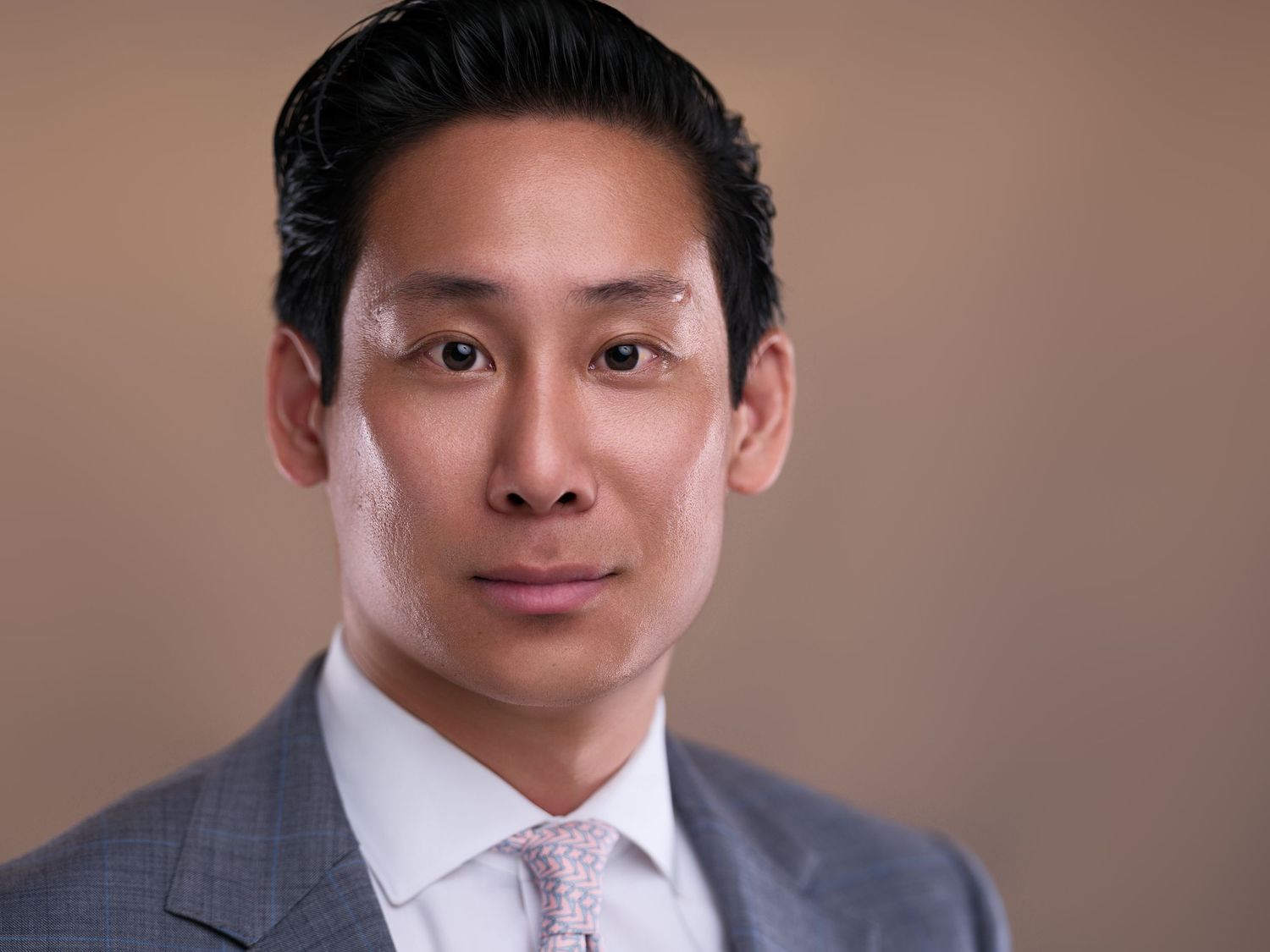 Professional headshots showing person in business attire against neutral backdrop in various poses.