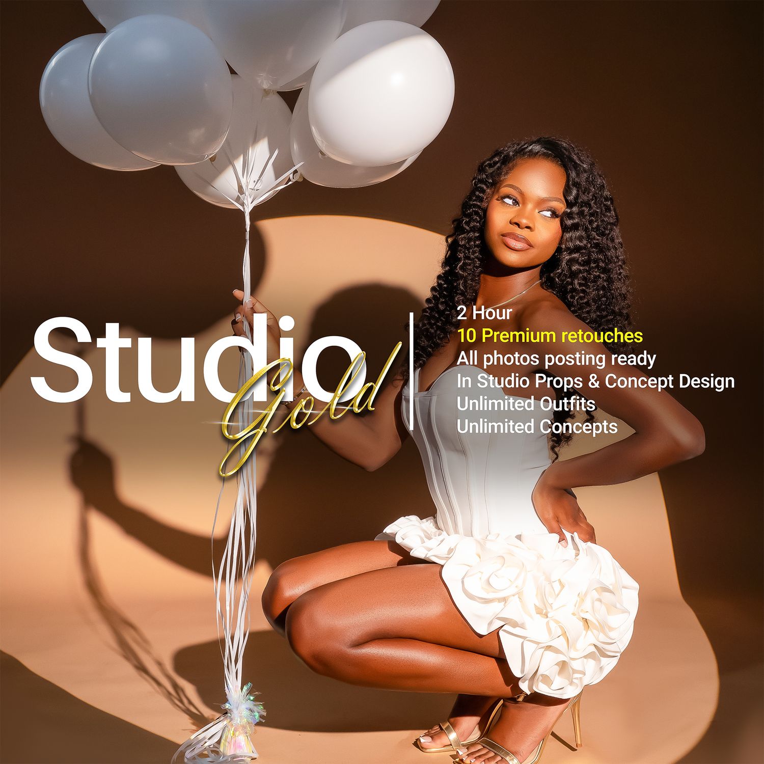 Young woman poses in studio gold photography session with white balloons and elegant white dress.