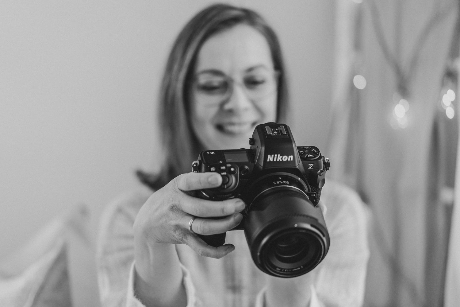 Photographer using a Nikon camera in black and white portrait style.