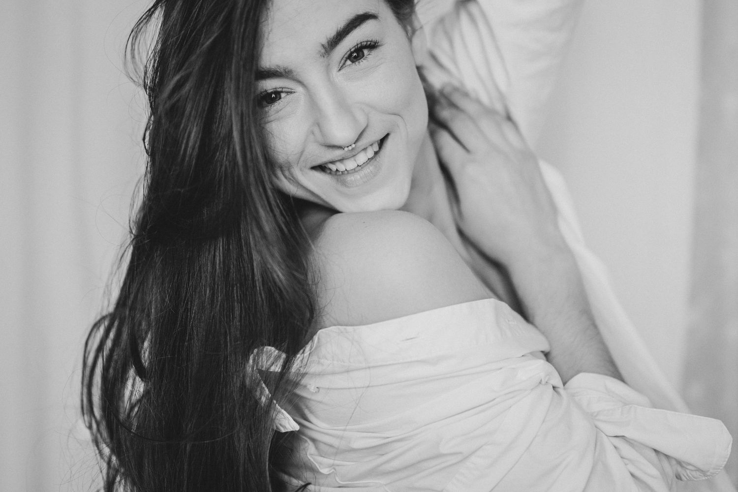 A series of four close-up portraits of a woman with long dark hair and a radiant smile wearing a white top.