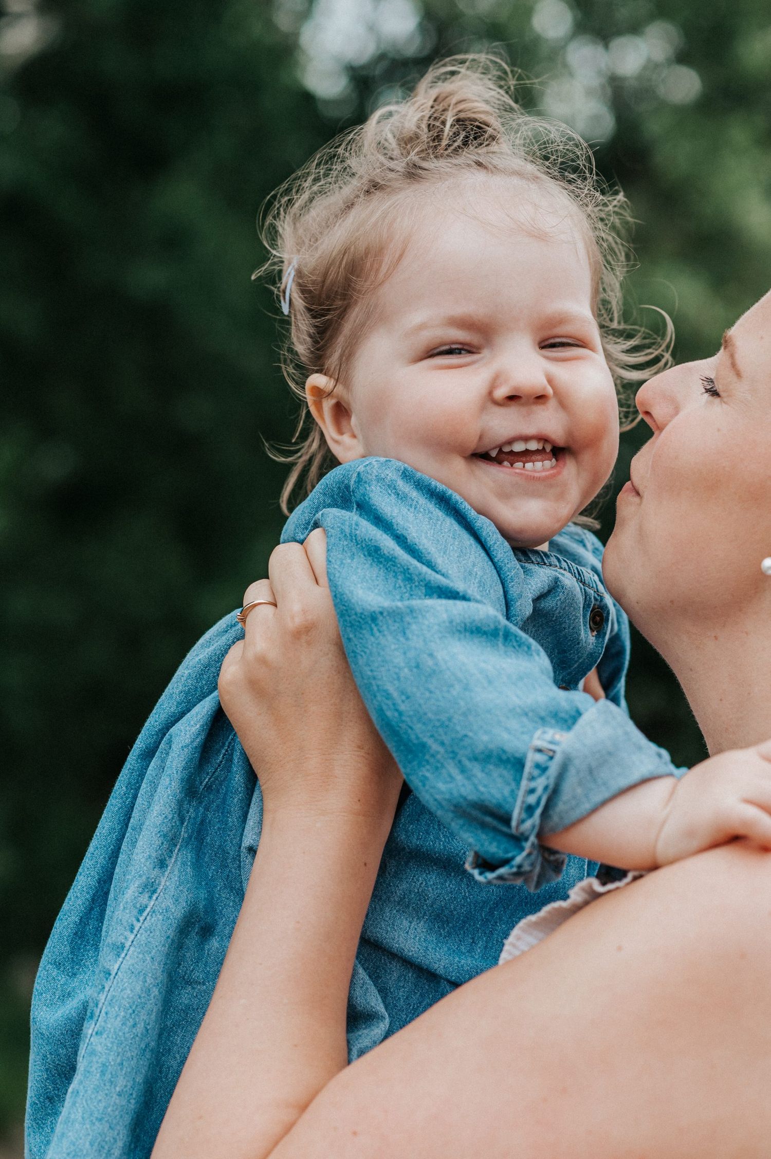 A heartwarming moment of joy and laughter between parent and child outdoors.