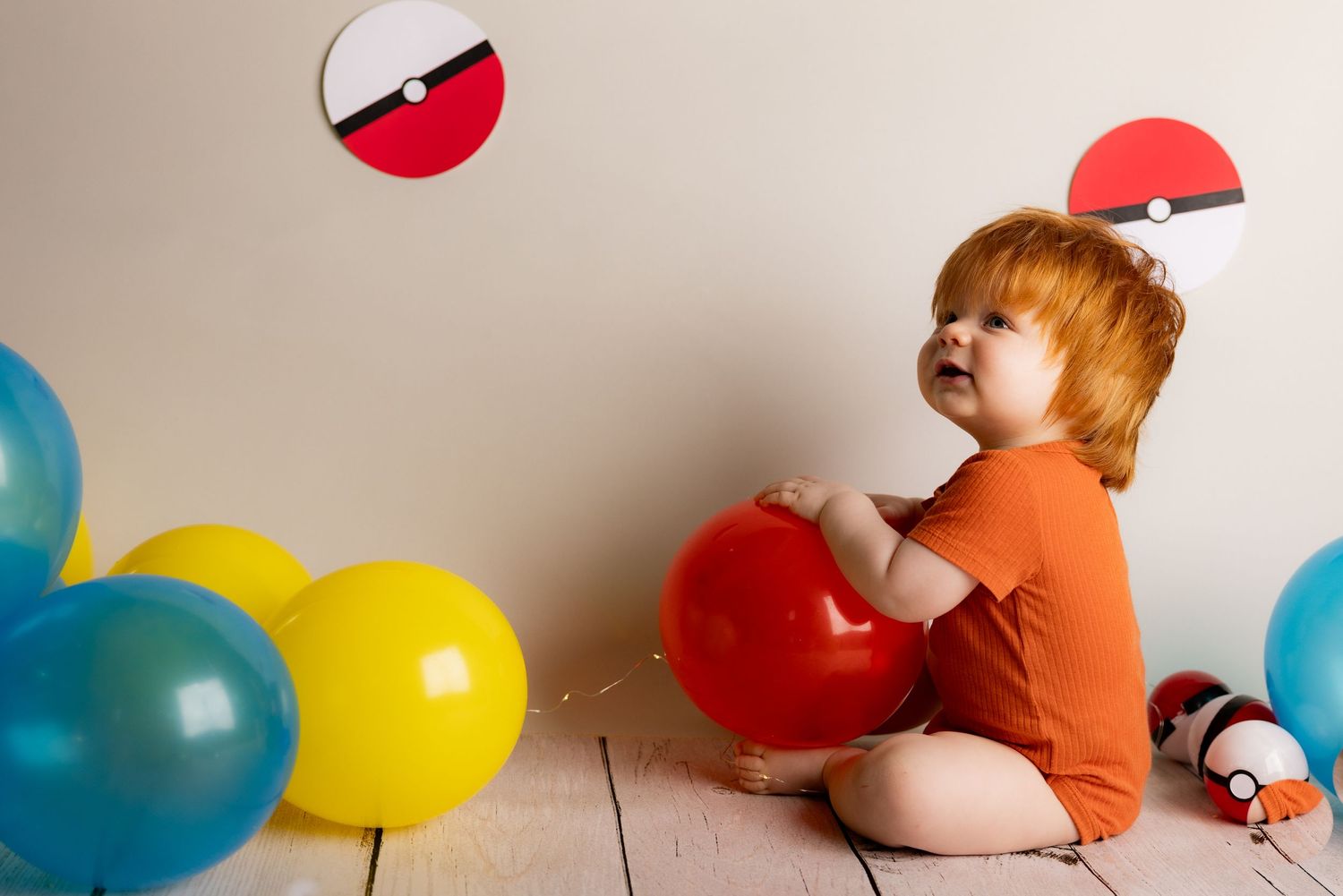 A creative photo series showing colorful balloons being popped in sequence against a beige wall.