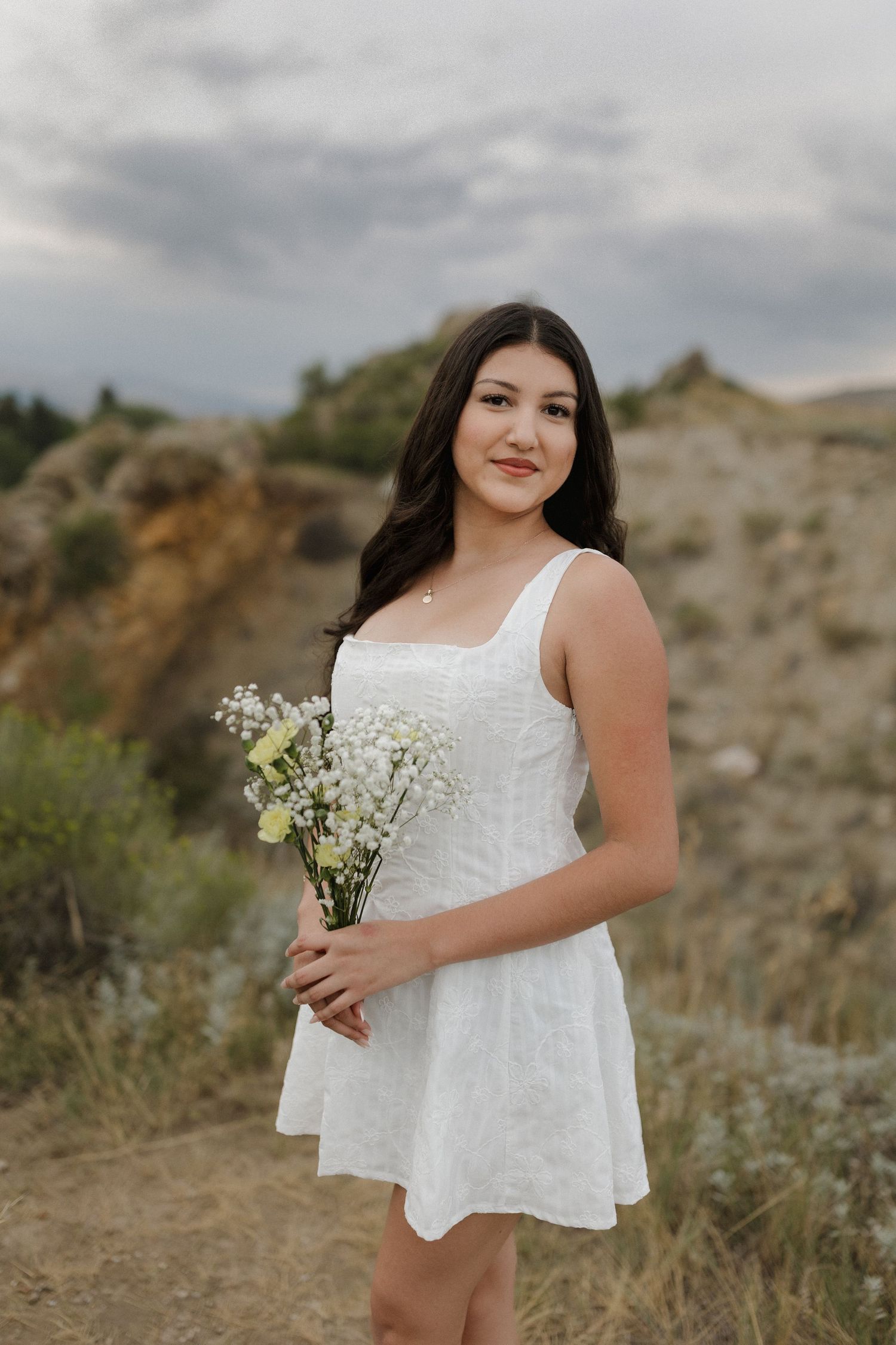 A white sundress stands out against rugged terrain and cloudy skies in this outdoor photo series.