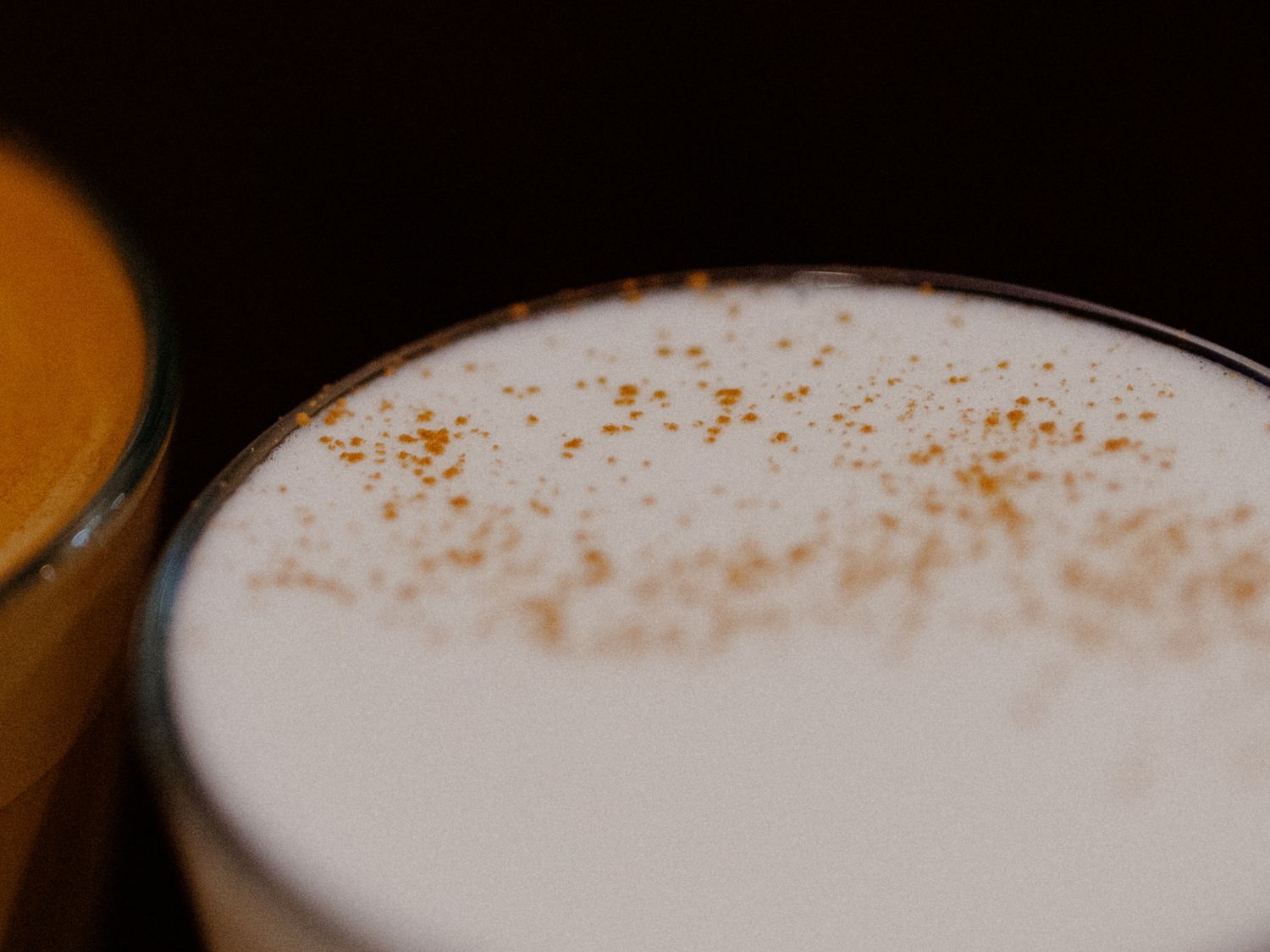 A close-up sequence showing the gradual formation of creamy foam on top of a dark espresso drink.