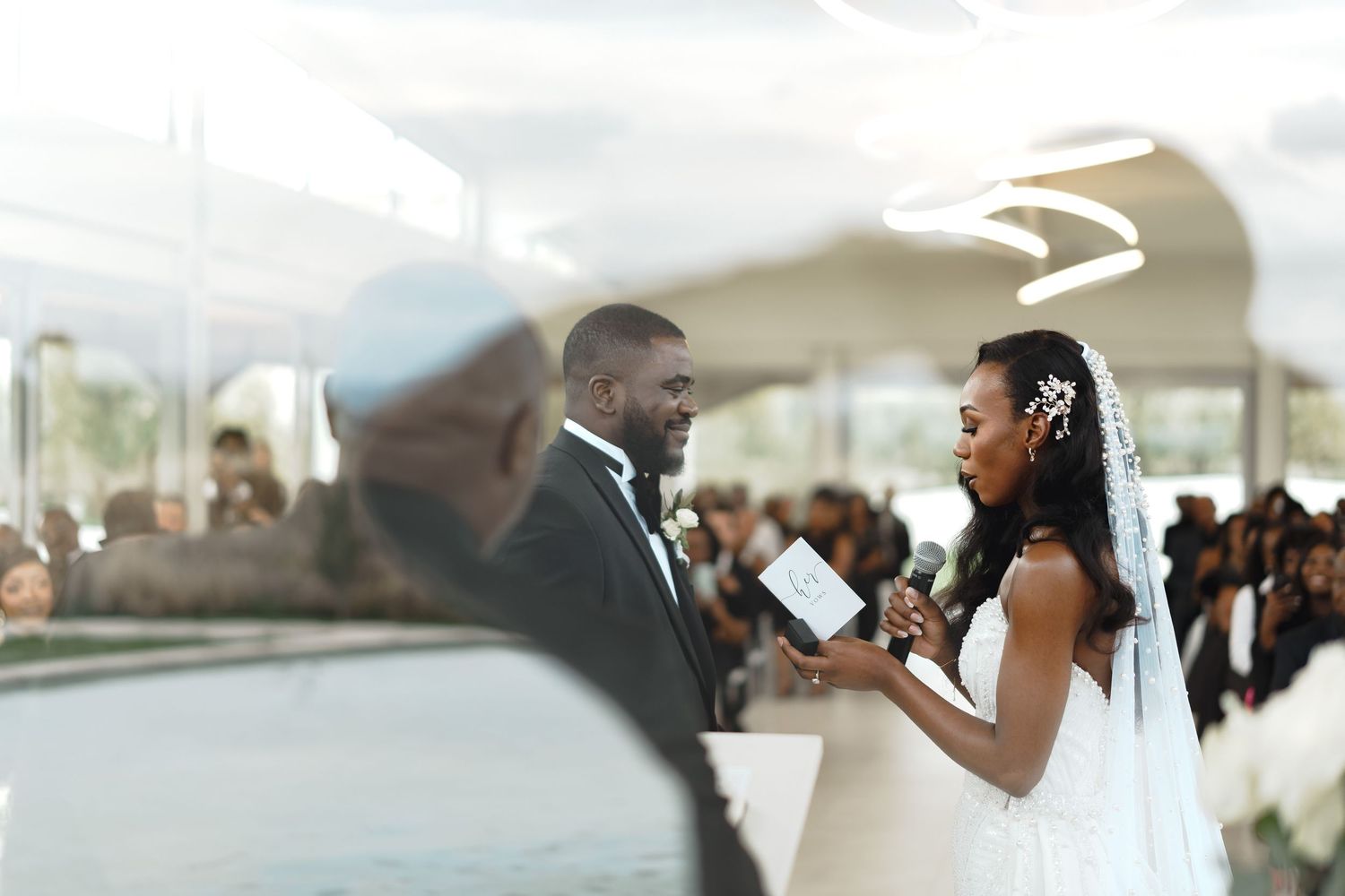 A wedding reception celebration with guests dancing and mingling under an elegant white tent.