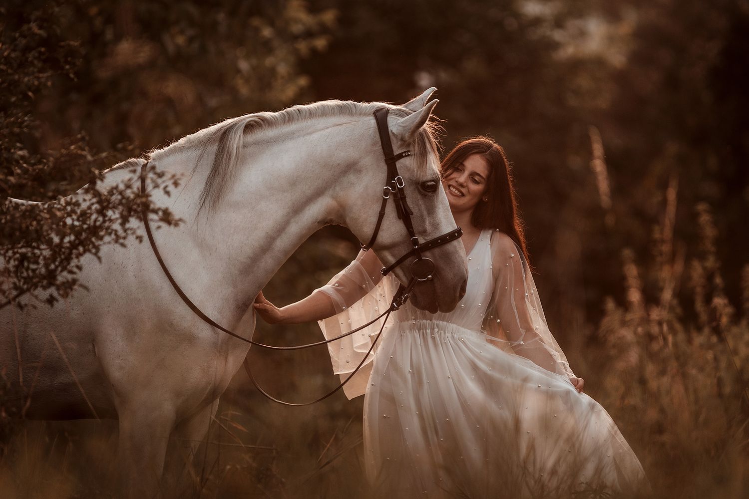 Weißes Pferd und hübsche Frau mit weißem Glitzerkleid