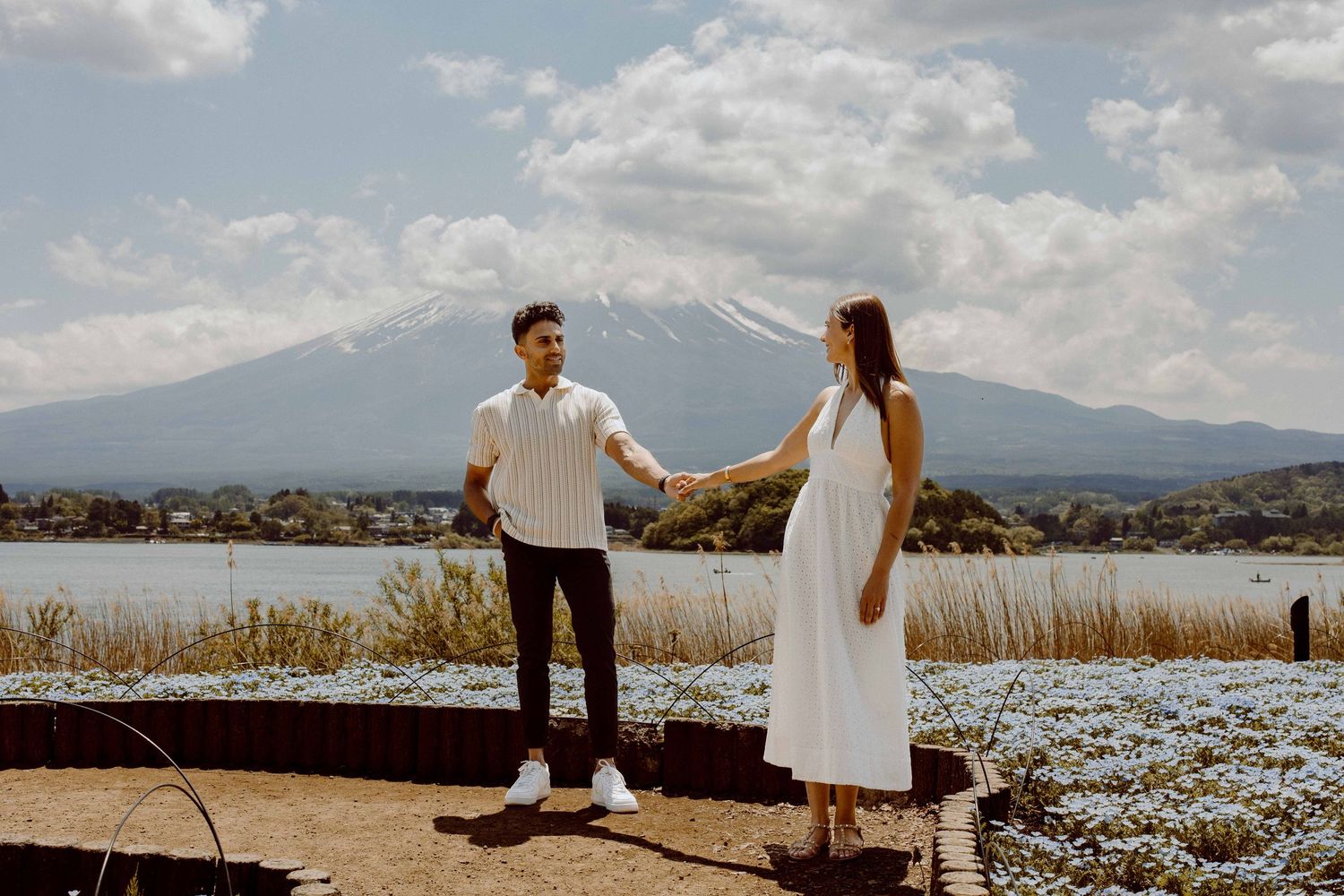 Couple poses on viewing platform with Mount Fuji landscape behind them.