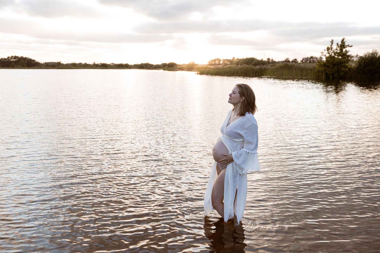 Udendørs gravidfotografering med bløde, naturlige farver