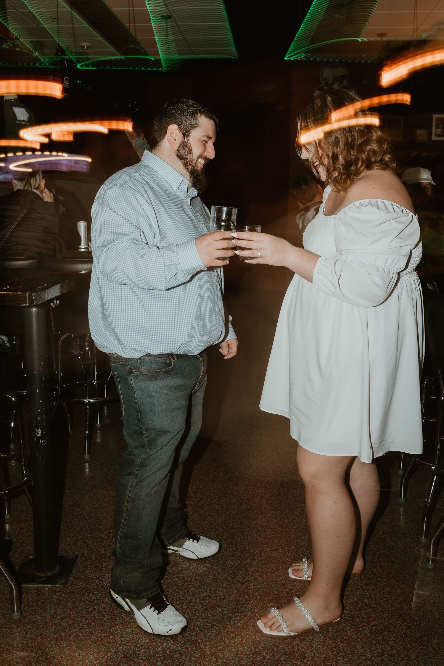 Couples picture celebrating engagement in a bar