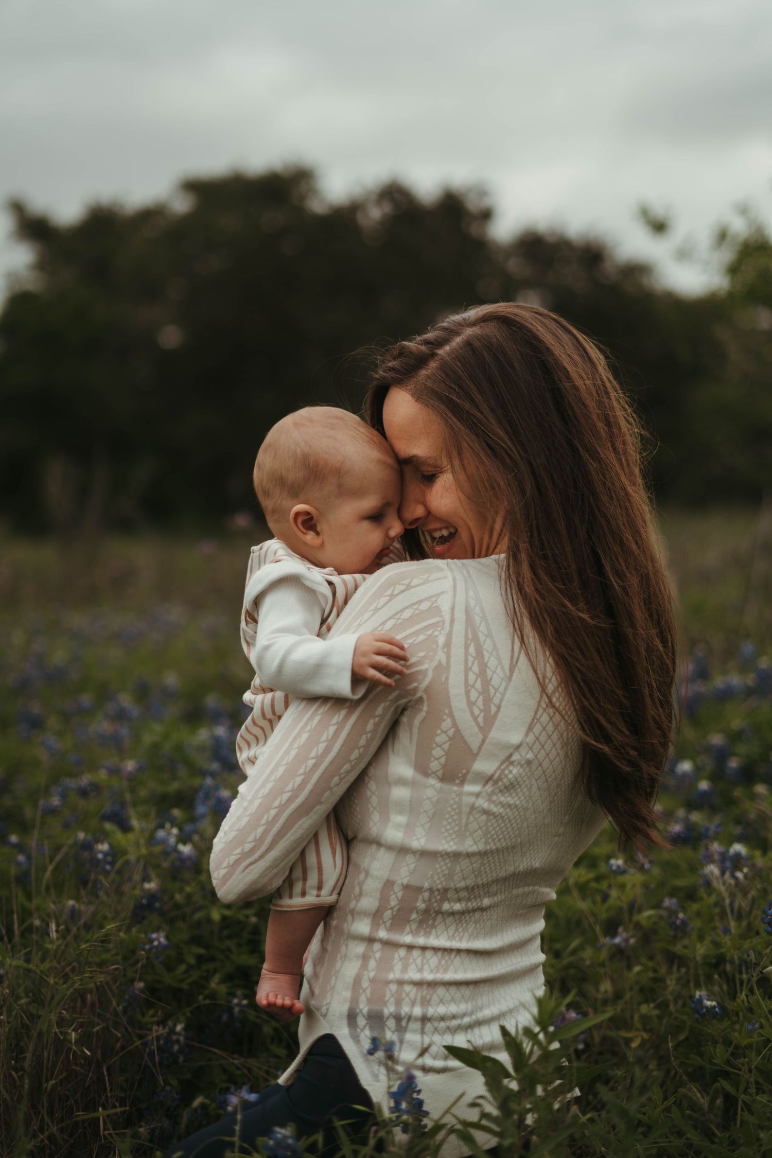 A tender moment shared between parent and child in a field of purple wildflowers at golden hour.