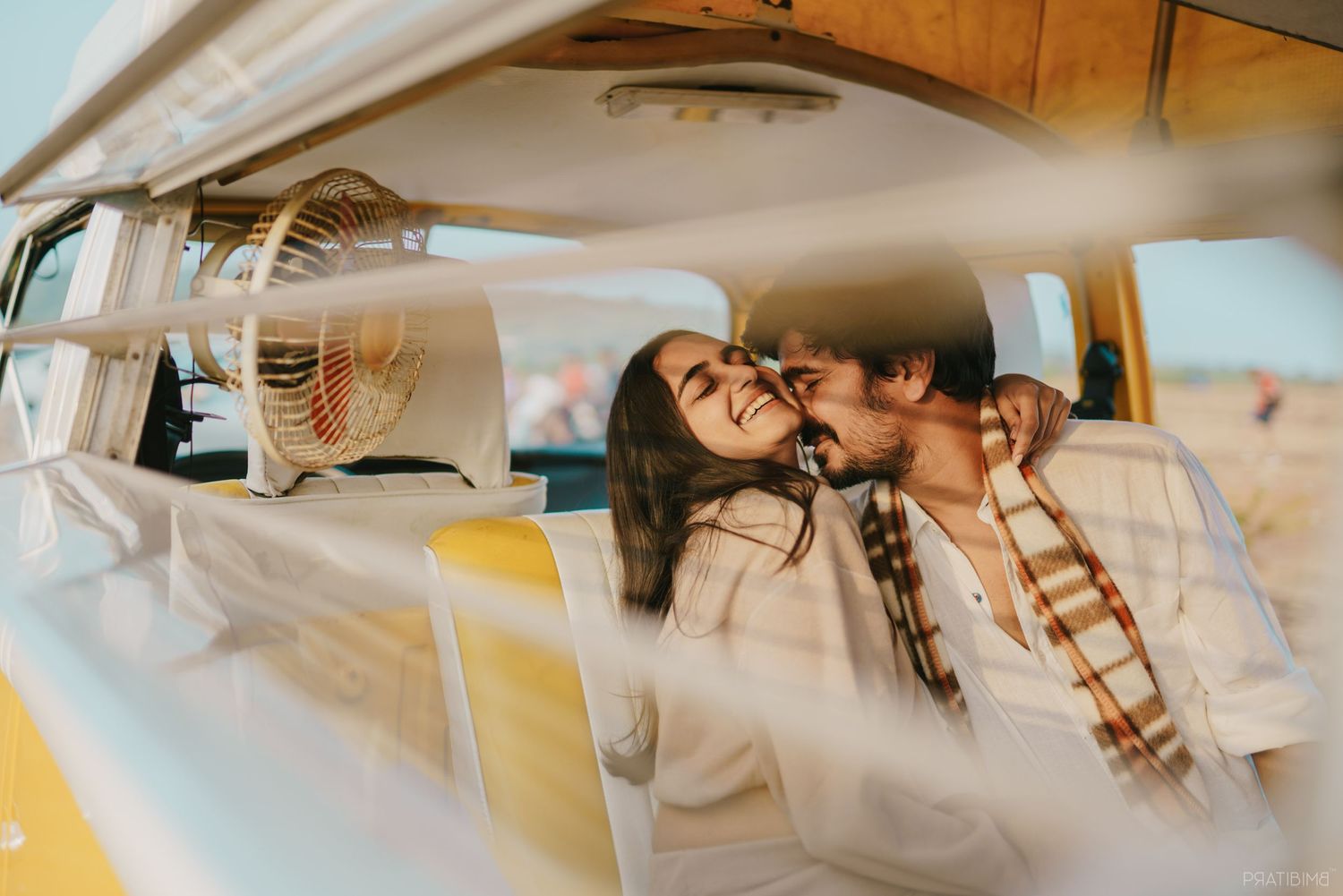 Intimate moment captured through car window as couple shares affection.