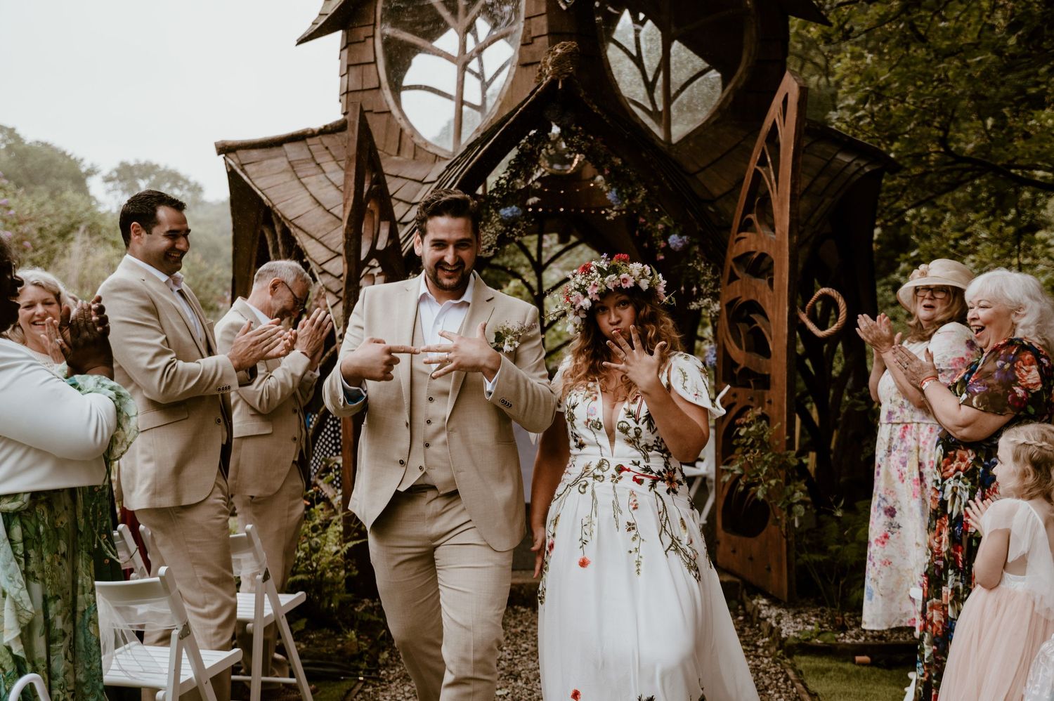 Wedding ceremony celebration at rustic outdoor venue with floral decorations and wooden gazebo in garden setting at St Nectans Glenn.