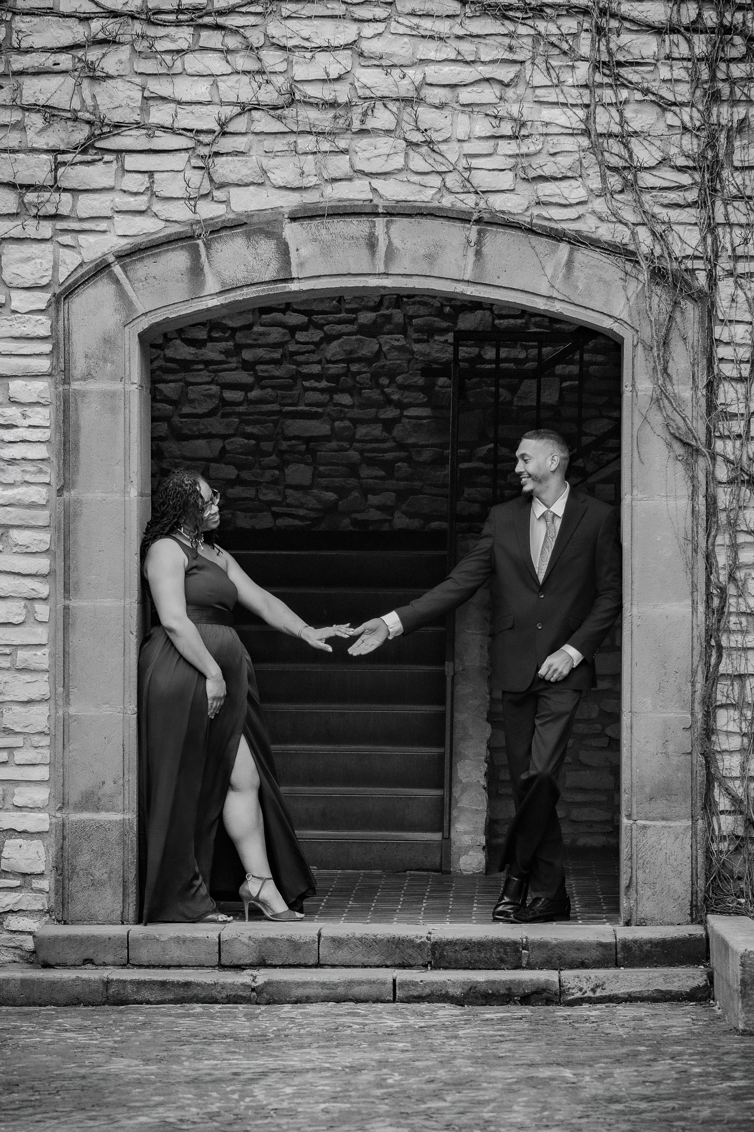 Artistic black and white photo sequence showing a couple in formal attire posing playfully in stone window frames.