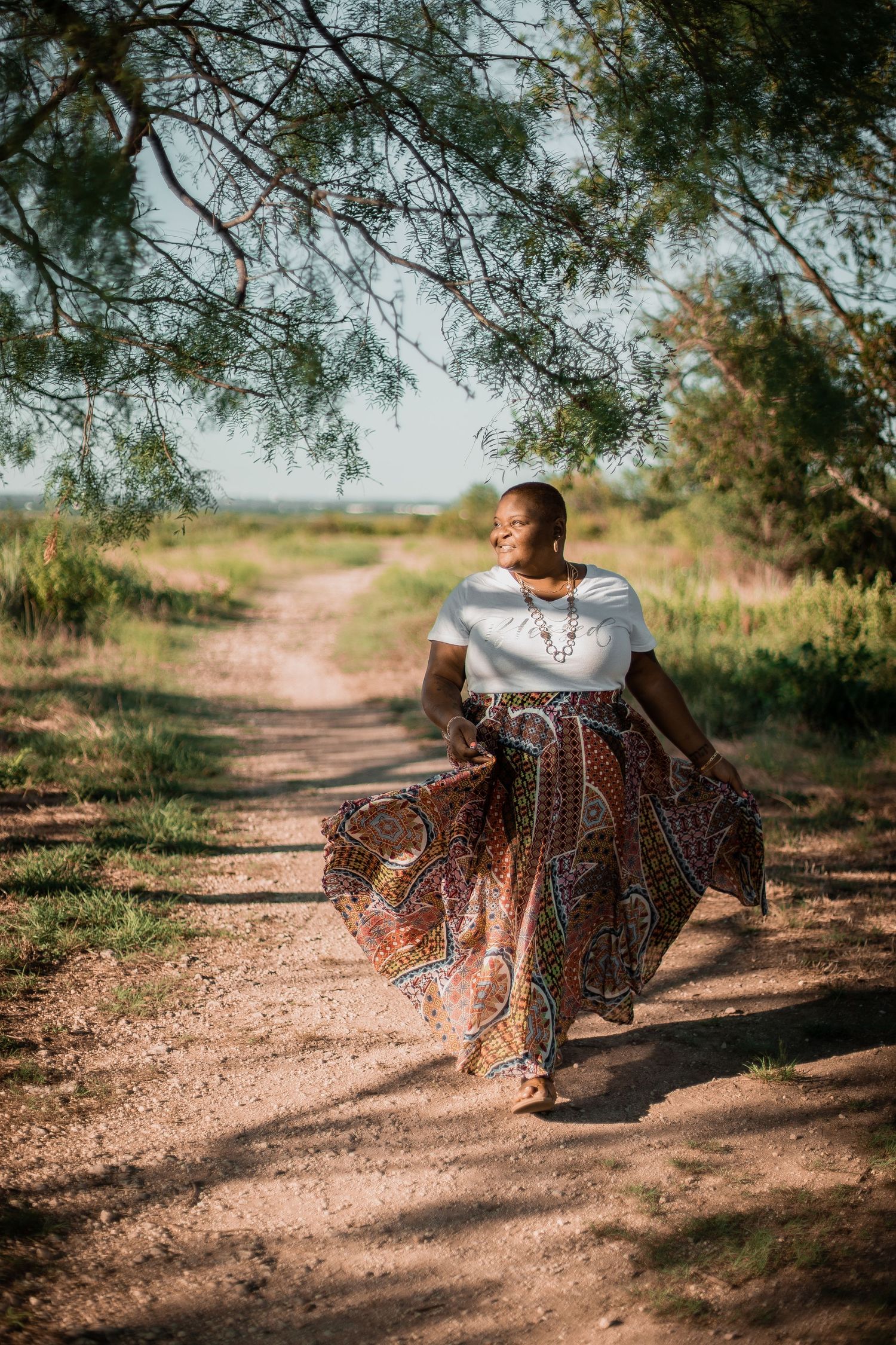 Flowing skirt movement captured on a dirt path surrounded by trees.