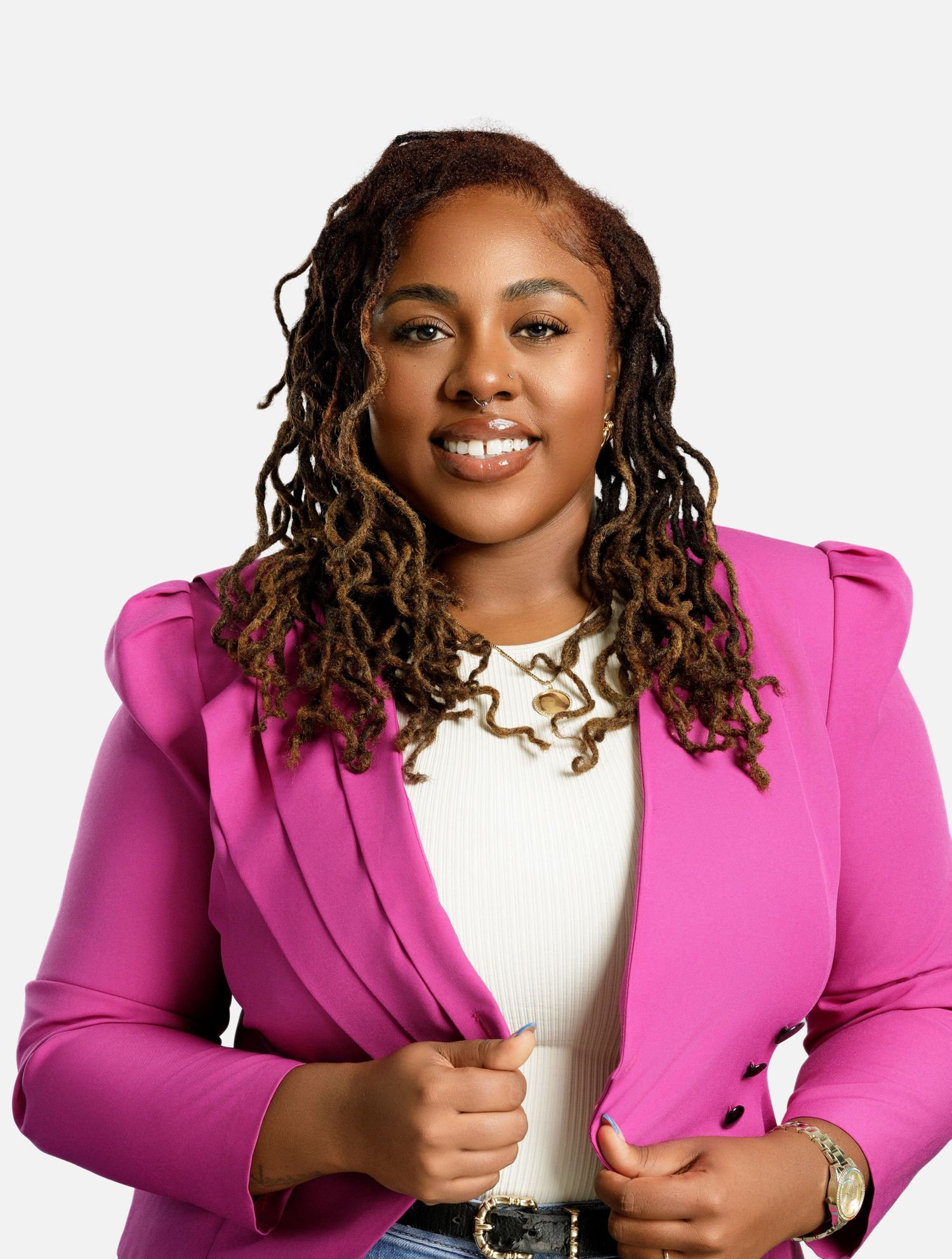Vibrant pink blazer styled with white top and gold chain necklace in professional photoshoot.