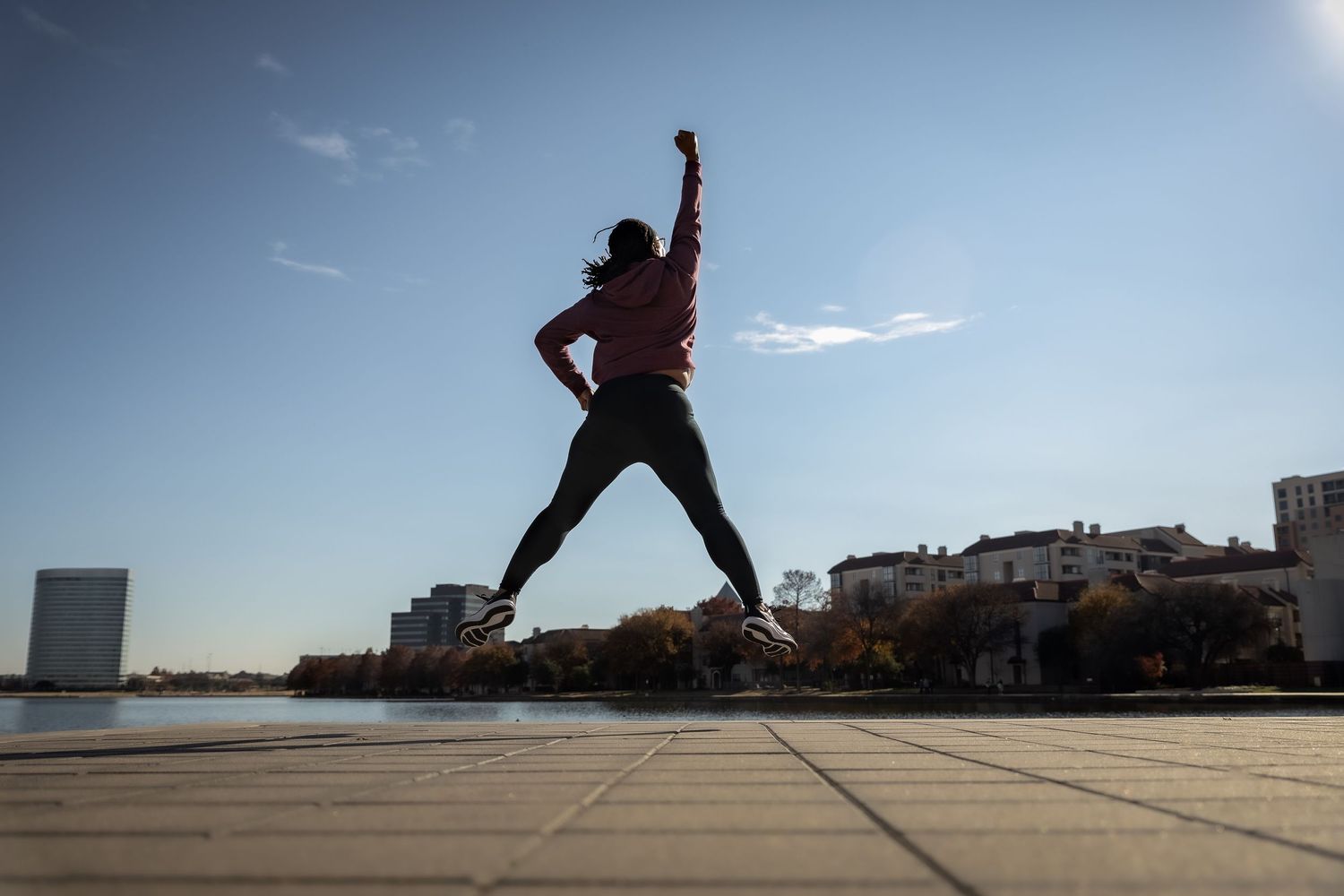 Dynamic rooftop parkour sequence with person leaping across urban landscape.