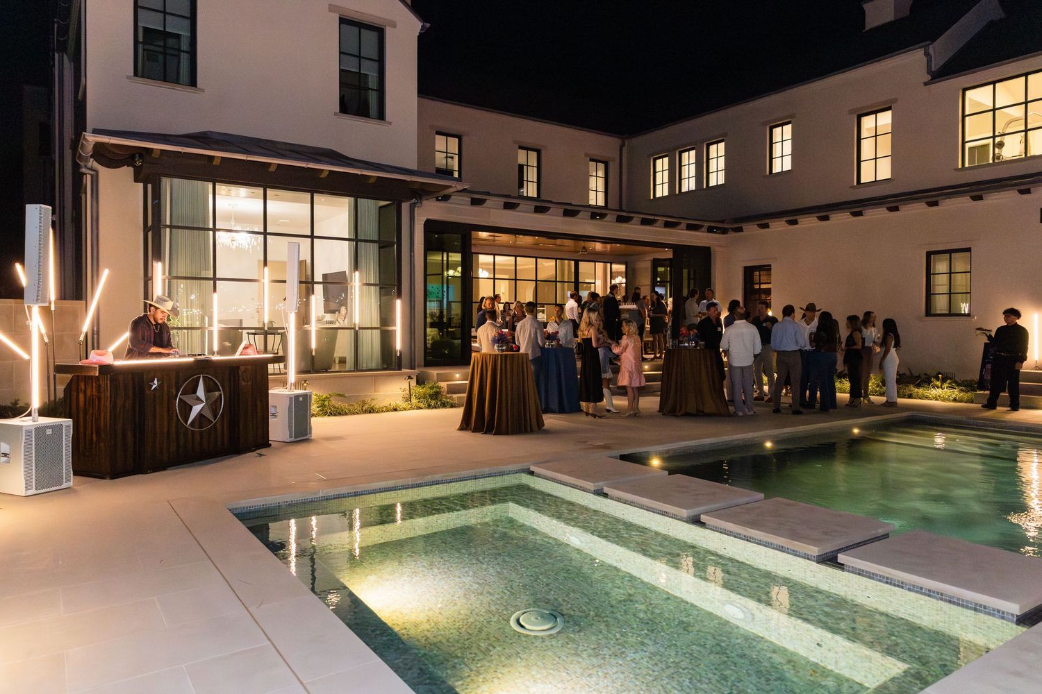 Illuminated indoor swimming pool at night with modern architectural features and warm lighting throughout the space.