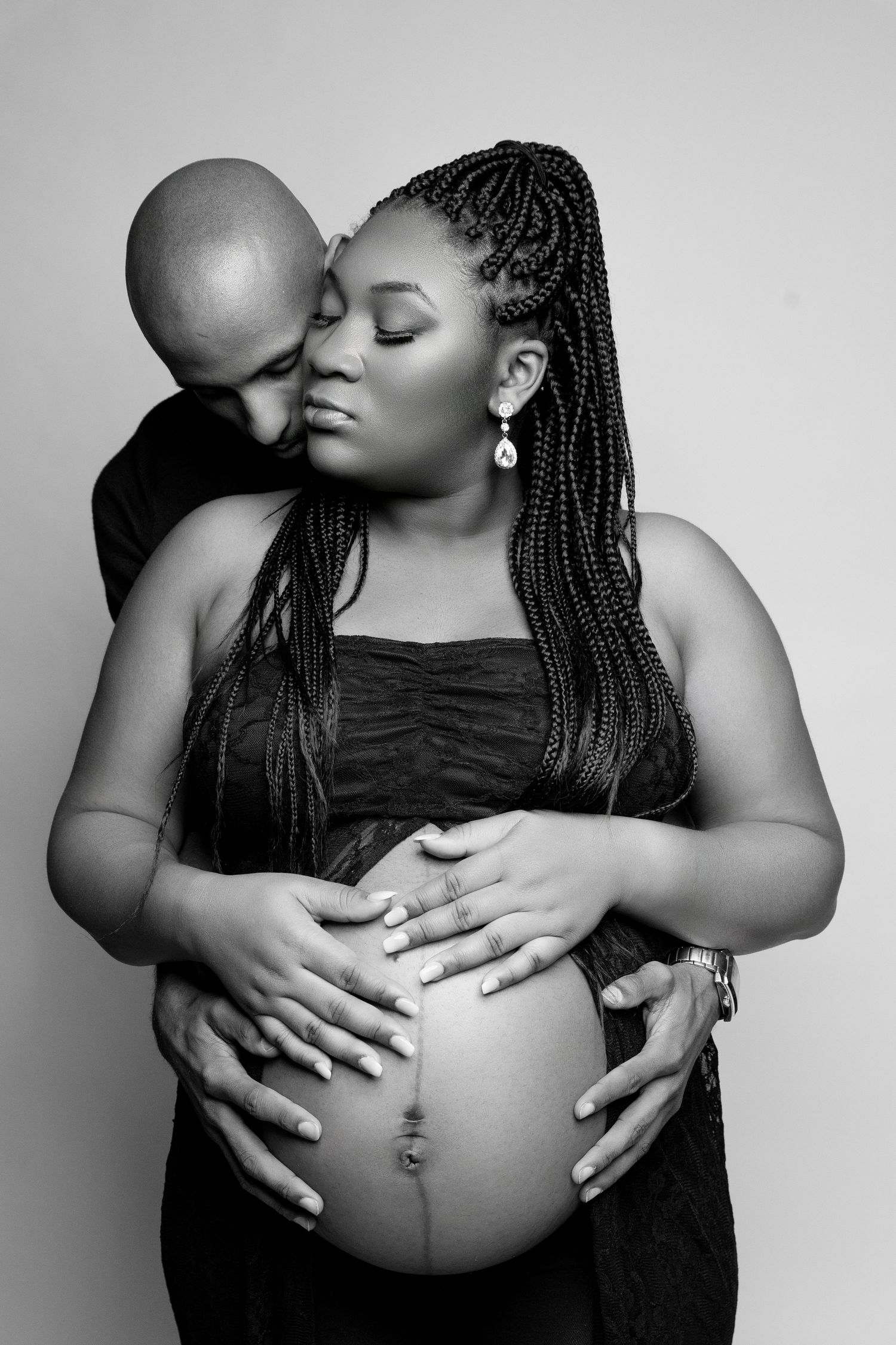 A series of intimate black and white maternity photos showing tender moments between a couple during pregnancy.