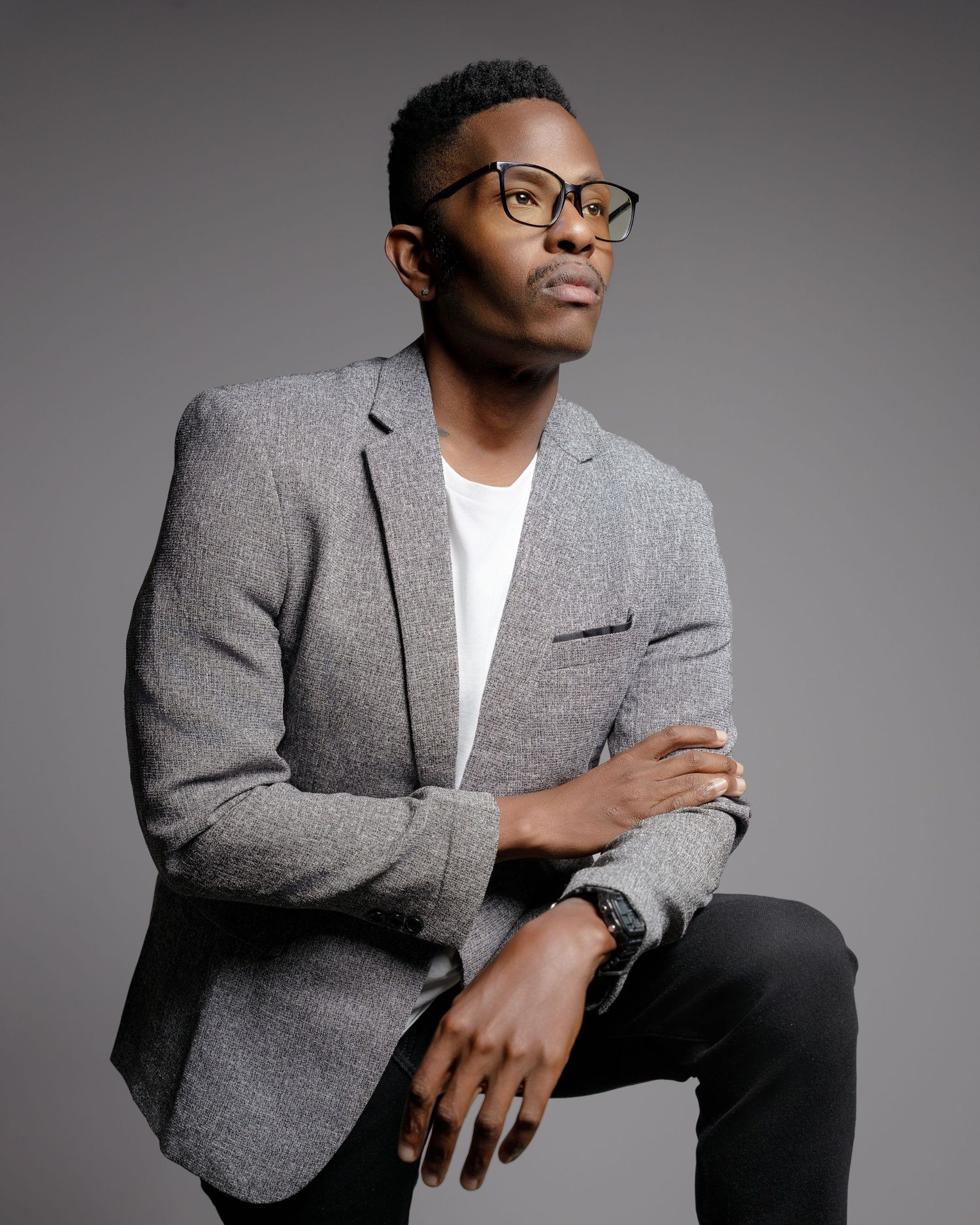 Fashion portraits showing various poses in grey textured blazer against studio backdrop.