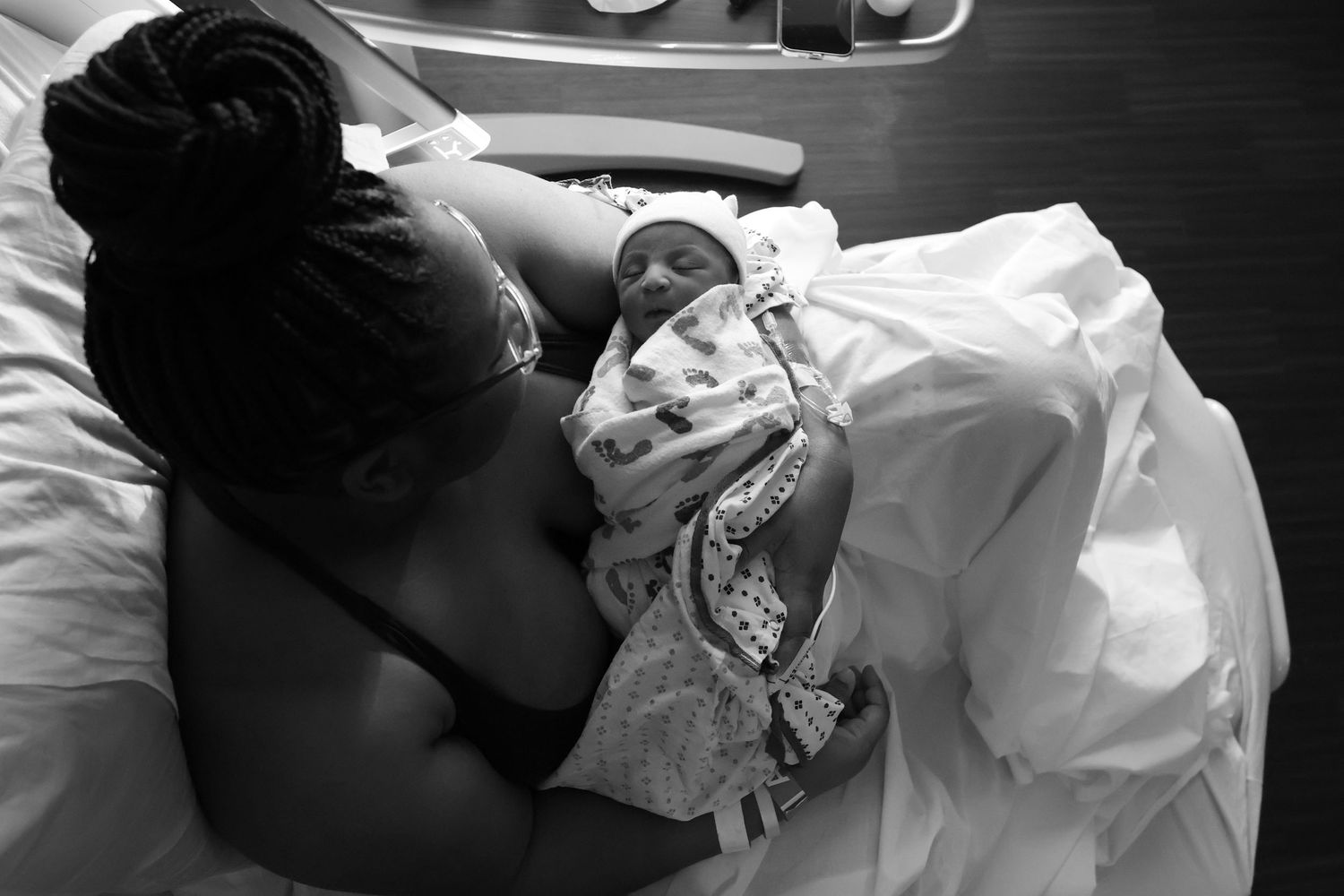 A series of black and white photographs showing tender moments between a parent and newborn baby in a medical setting.