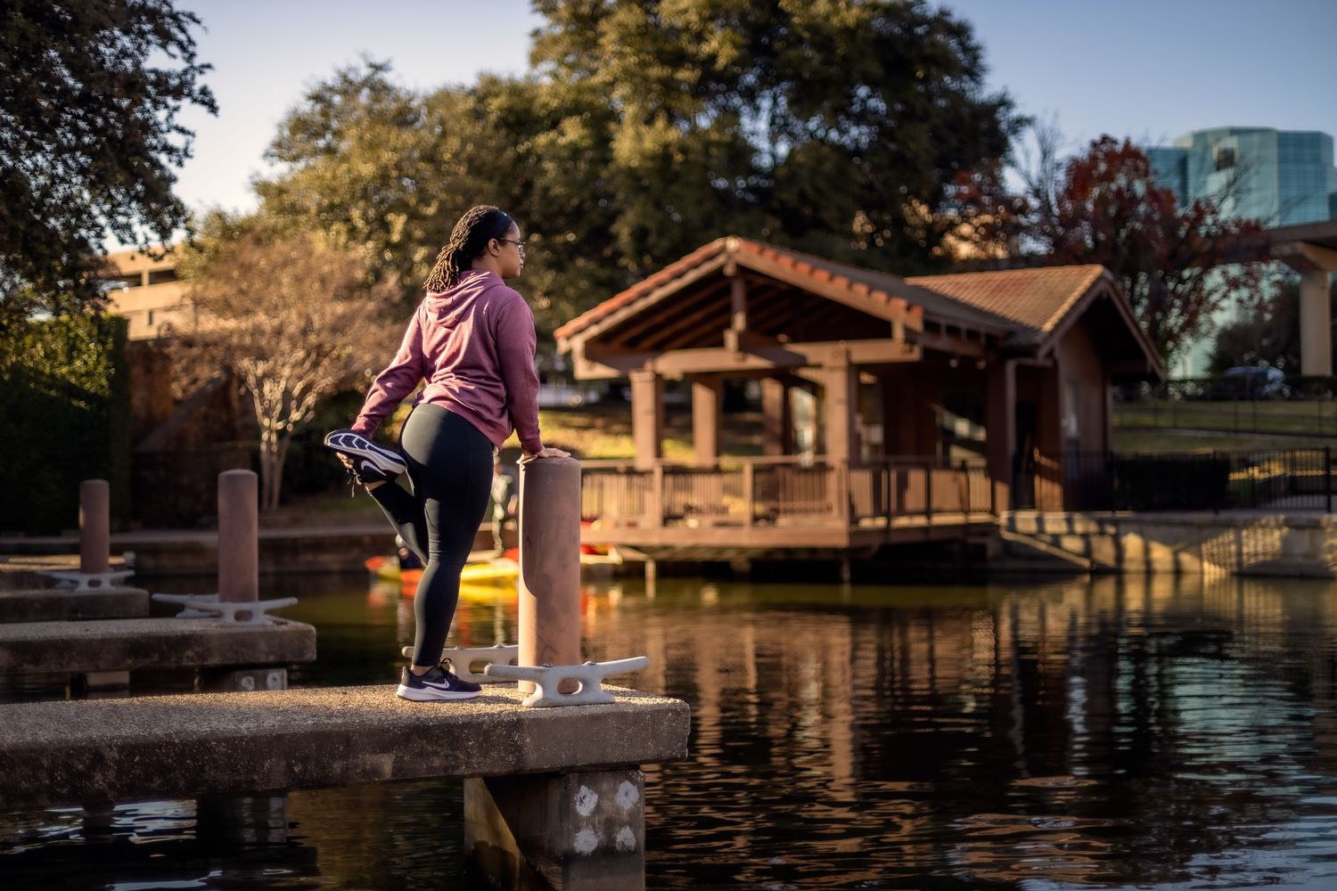 Person performing acrobatic moves near waterfront park with wooden structures.
