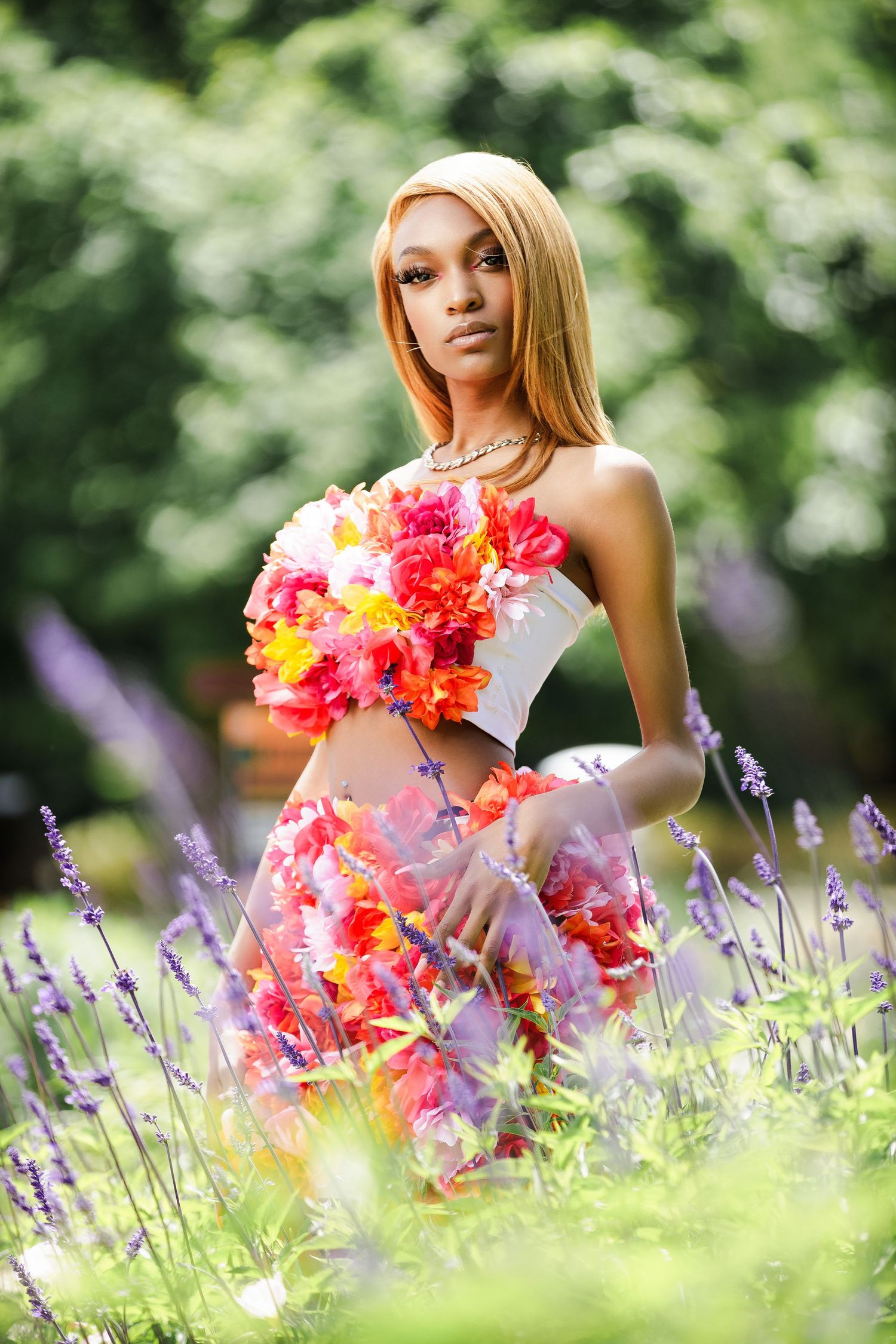 Ethereal garden photoshoot featuring bright floral dress design among lavender blooms.