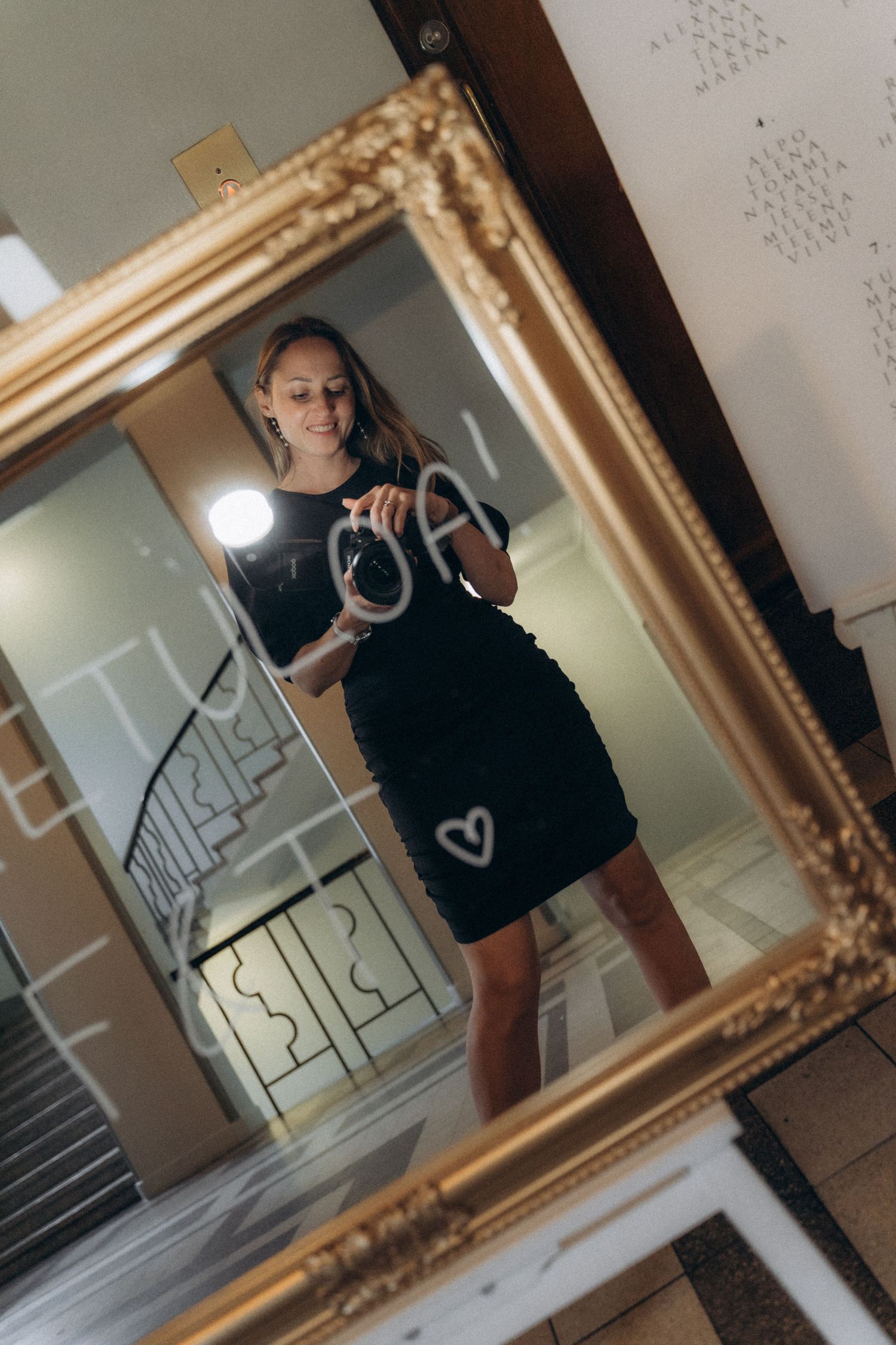 Wedding photographer Polina reflected in mirror while documenting authentic moments during wedding day coverage
