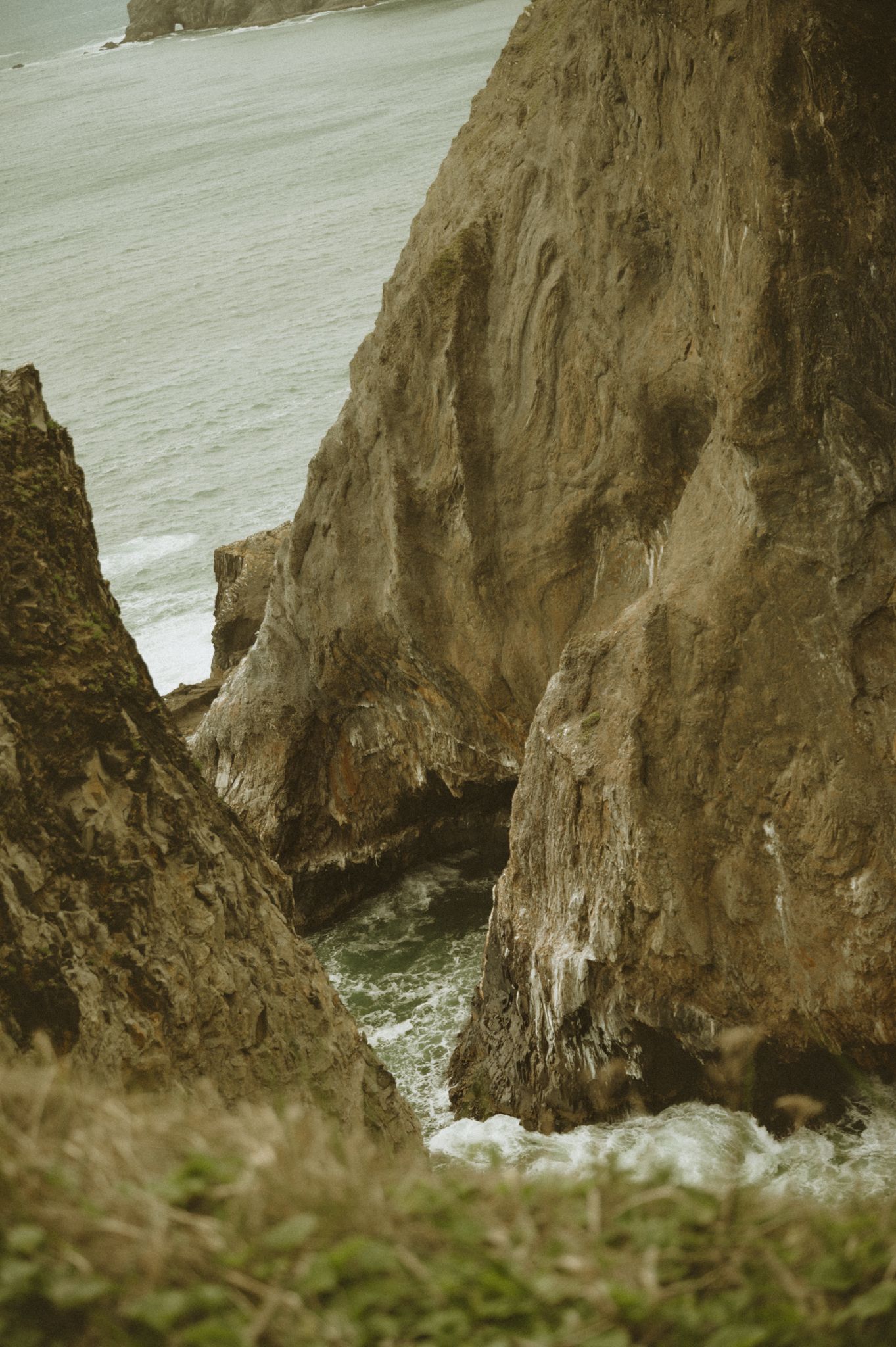 Dramatic coastal cliffs meeting the ocean, shown in a series of connected photographs.
