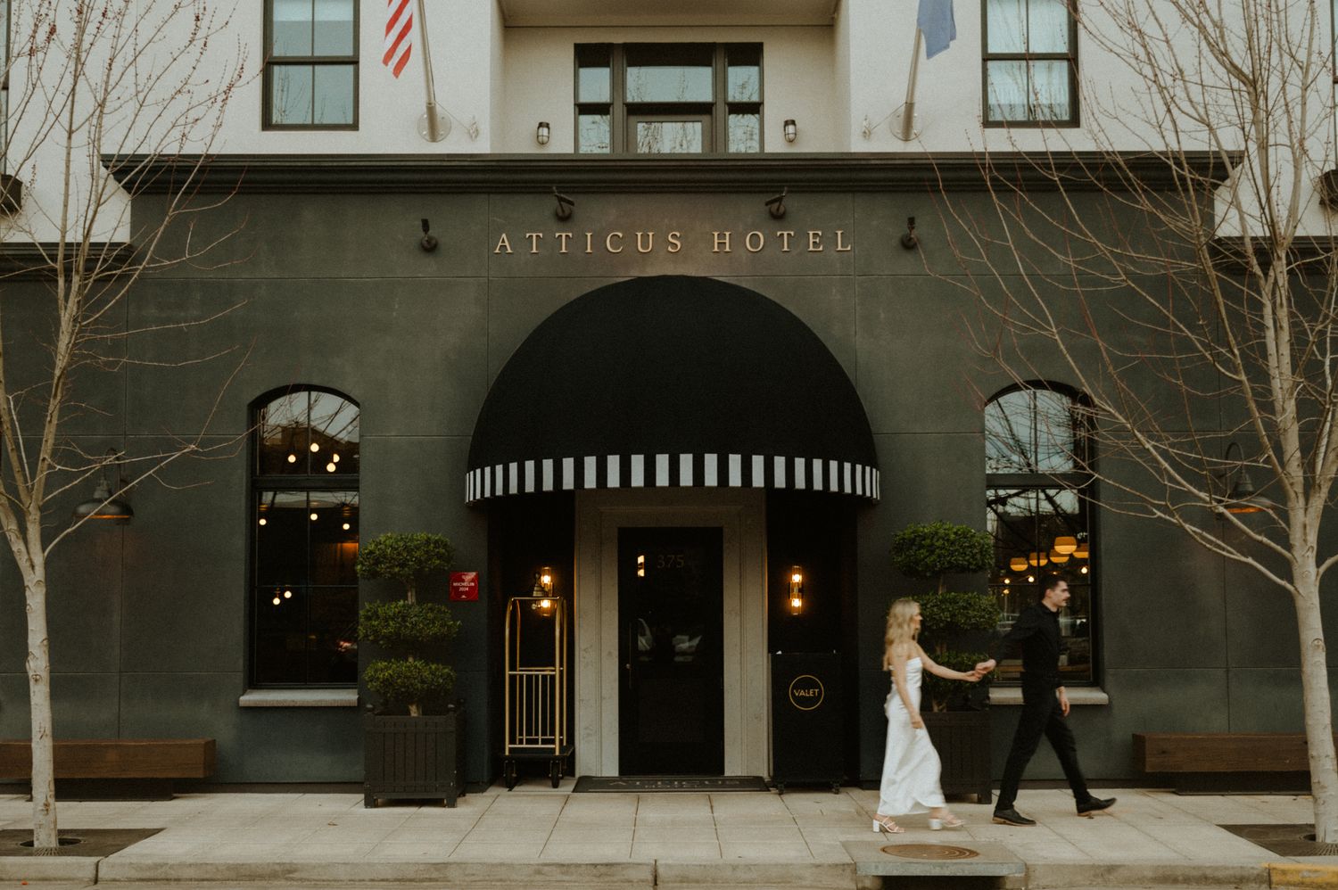 Exterior view of a modern hotel building with American flag and entrance.
