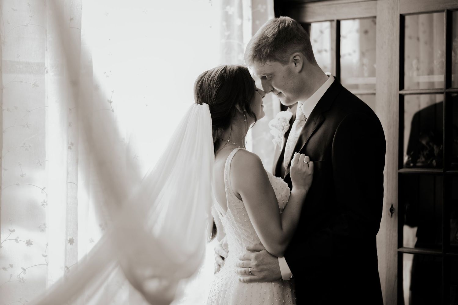 A romantic black and white wedding photo collage showing intimate moments between newlyweds in formal attire.