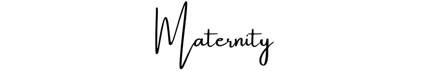 A hand holding a pen signs a signature in black ink on white paper.