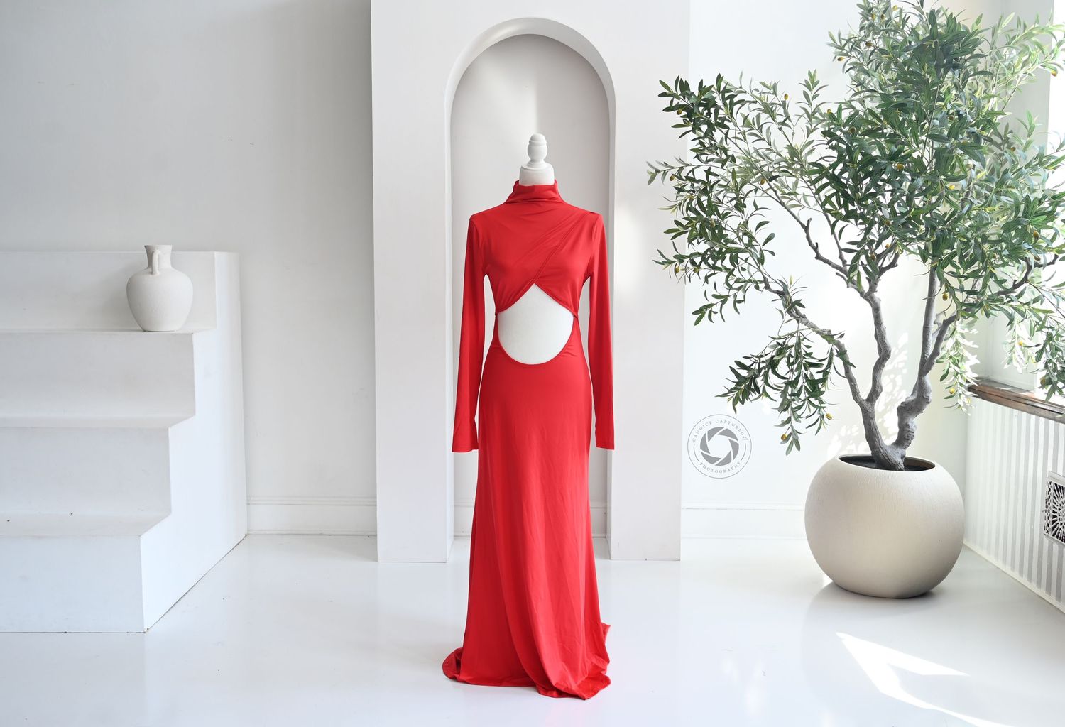 A minimal modern home interior collage featuring a red dress, white vases, and green plants against white walls.