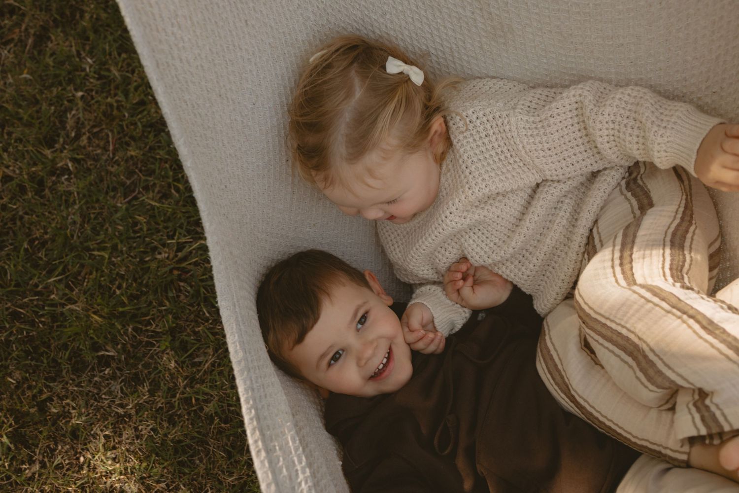 A wedding photographer captures candid moments of a couple laughing together in a sunlit outdoor setting.