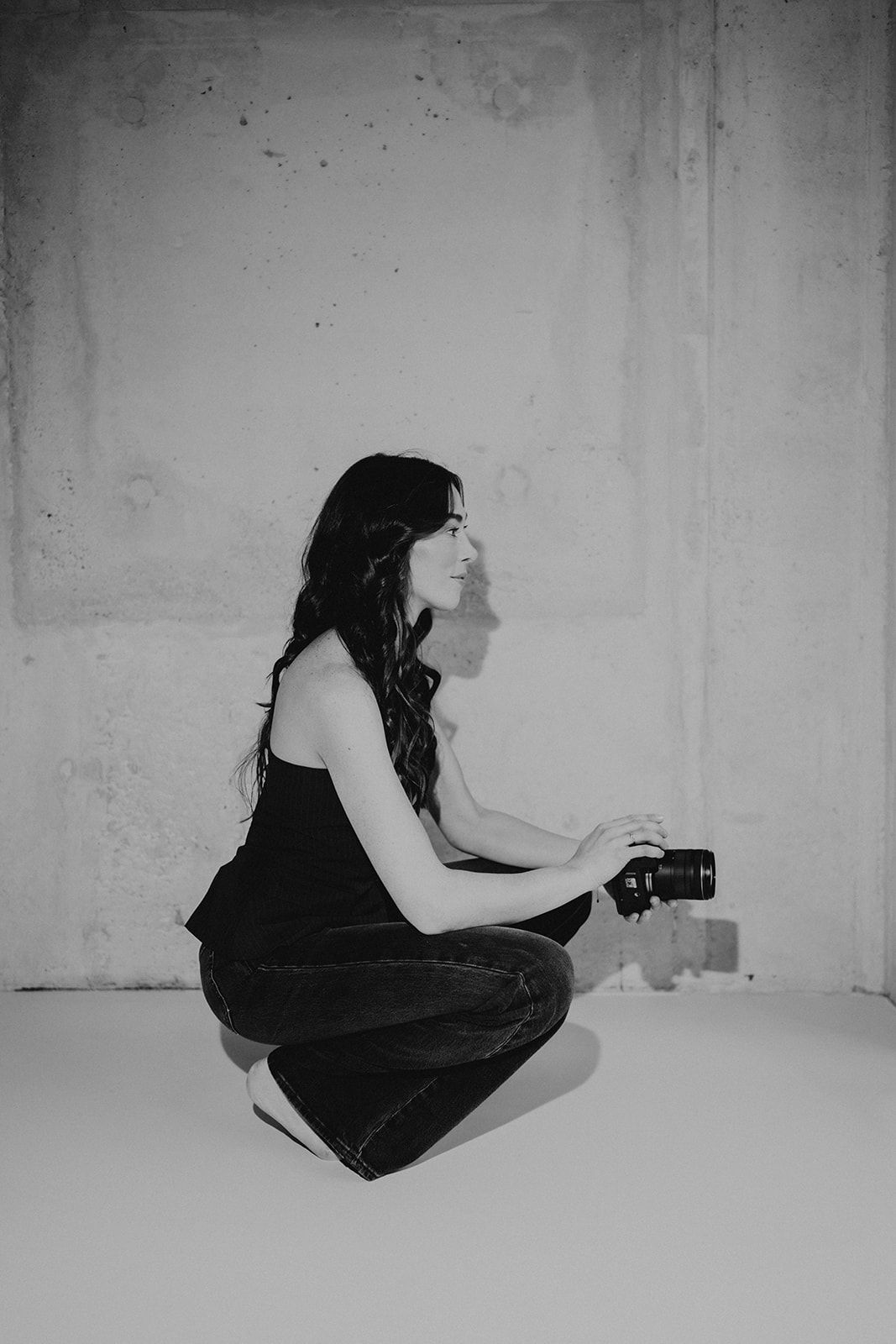 Artistic black and white photos of person in dark dress against white studio backdrop.
