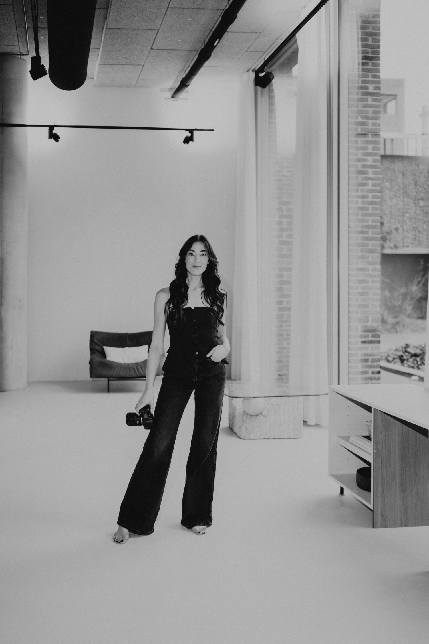 Black and white photo series showing a figure in dark clothing against a minimalist white studio backdrop.