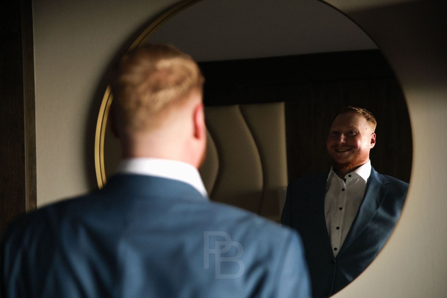 Aufnahme von einer Hochzeit.
Bräutigam schaut aufgeregt in den Spiegel.
(Ort: Timmendorfer Strand, Fotografin: Philina Becker)
