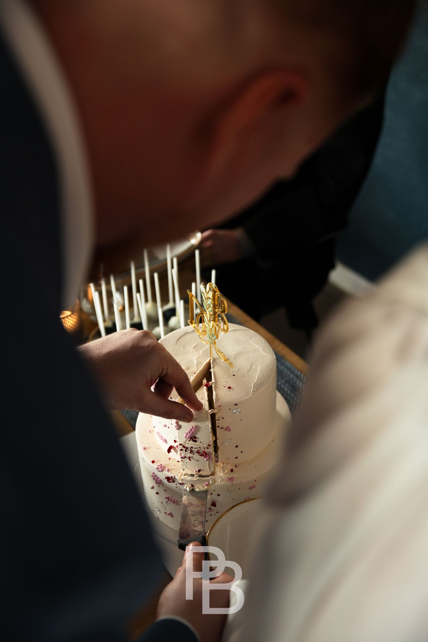Aufnahme von einer Hochzeit.
Bräutigam schneidet Torte an.
(Ort: Timmendorfer Strand, Fotografin: Philina Becker)