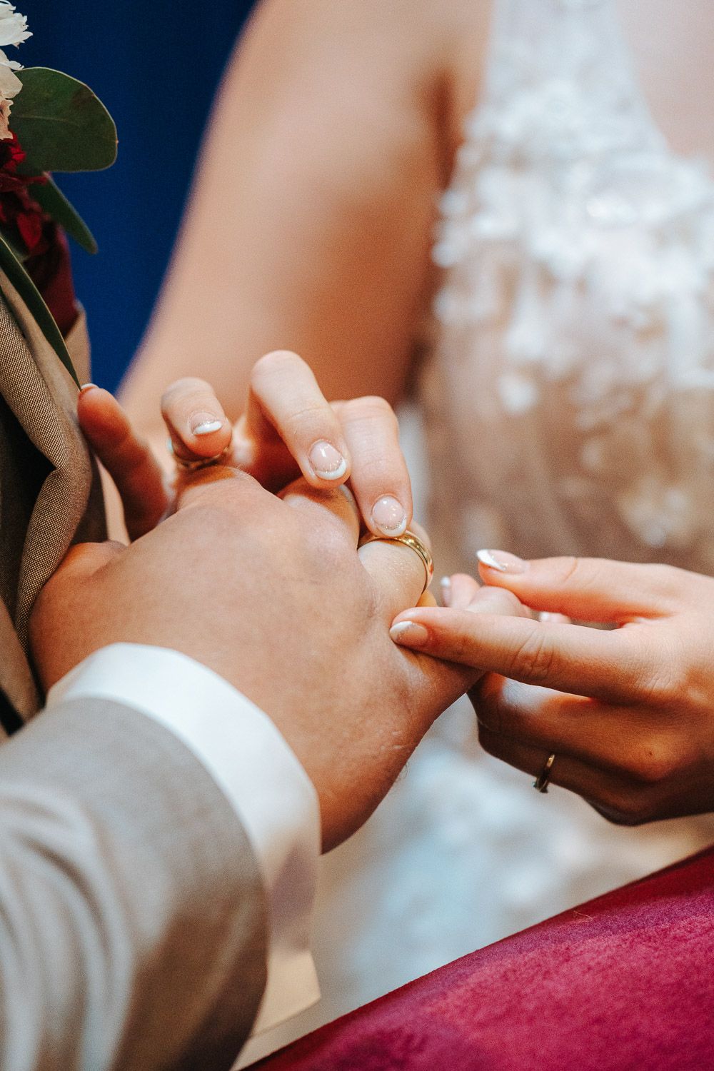 A series of close-up shots showing hands exchanging wedding rings during a ceremony against a dark blue background.
