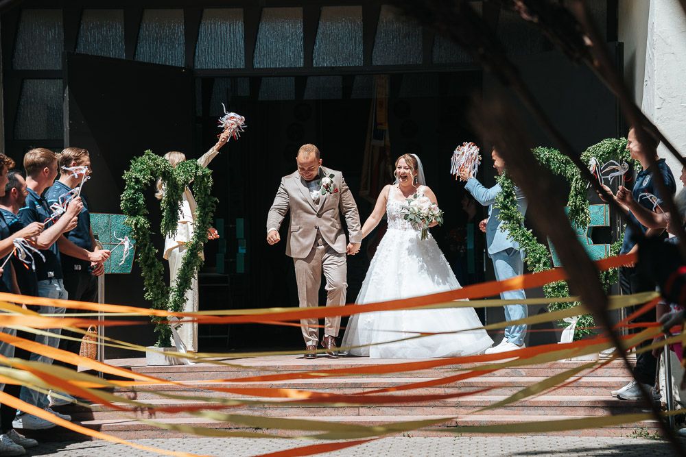 A creative wedding exit captured in a sequence of photos showing the couple ducking under crossed skis held by guests.