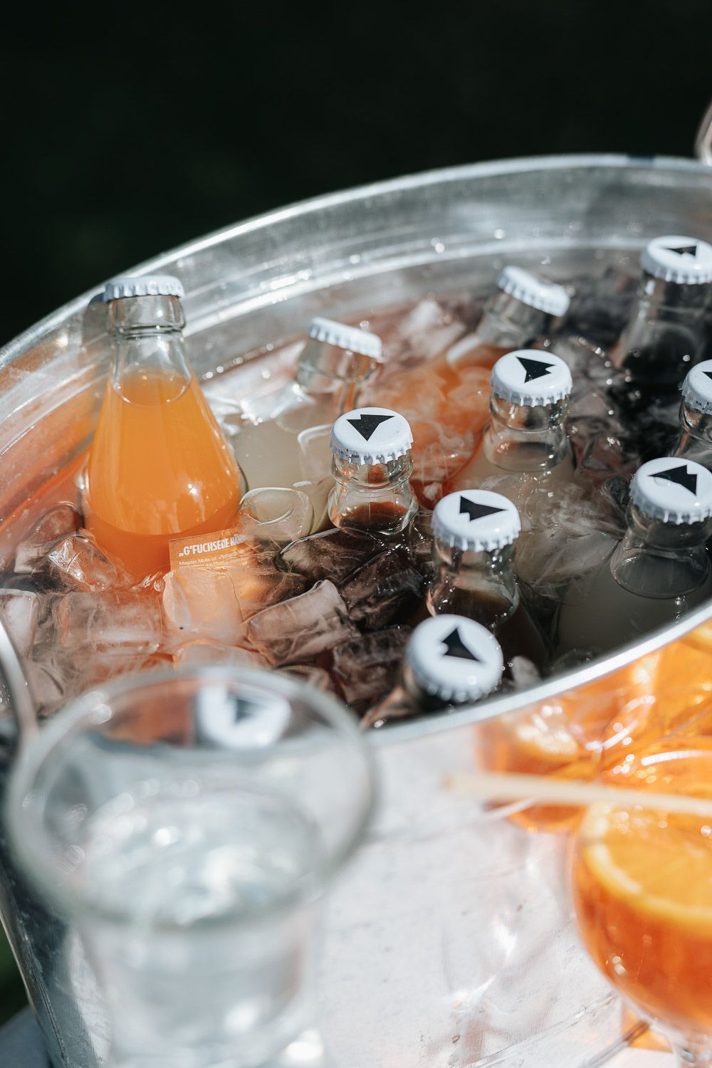 Closeup macro shot of ice cubes and orange slices in carbonated beverage showing crisp details and refreshing bubbles.