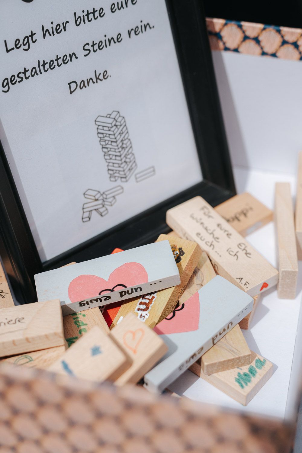 Close-up view of wooden blocks and paper cards with German text showing instructions or notes in a creative layout.