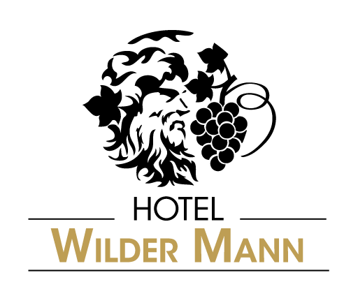 Black and gold logo for Hotel Wilder Mann featuring a wild man face surrounded by grape vines and birds.