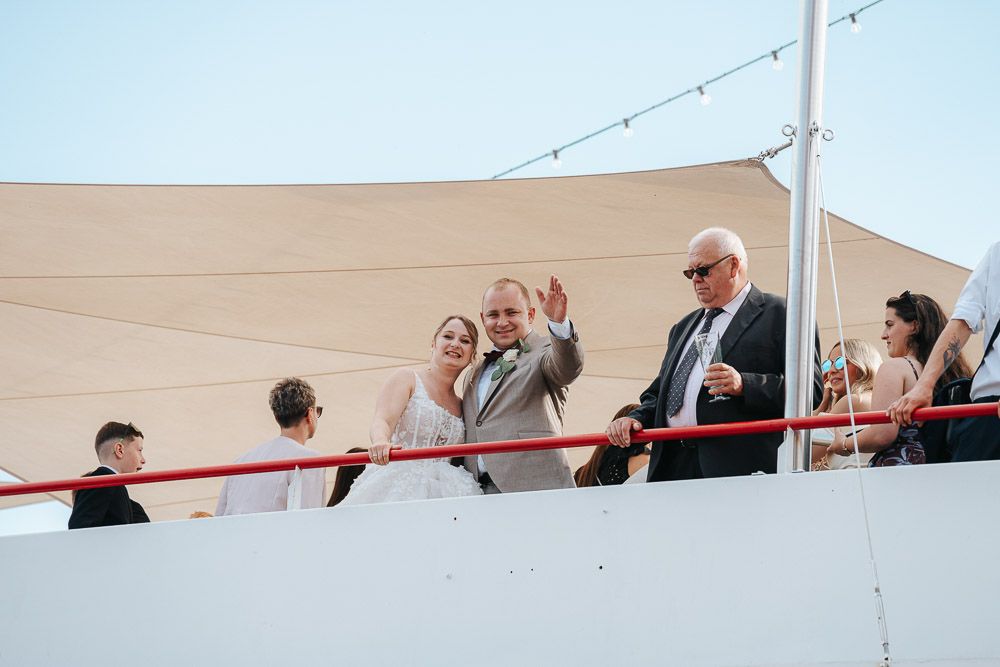 People gathered on an outdoor deck or balcony sharing a celebratory moment at sunset.